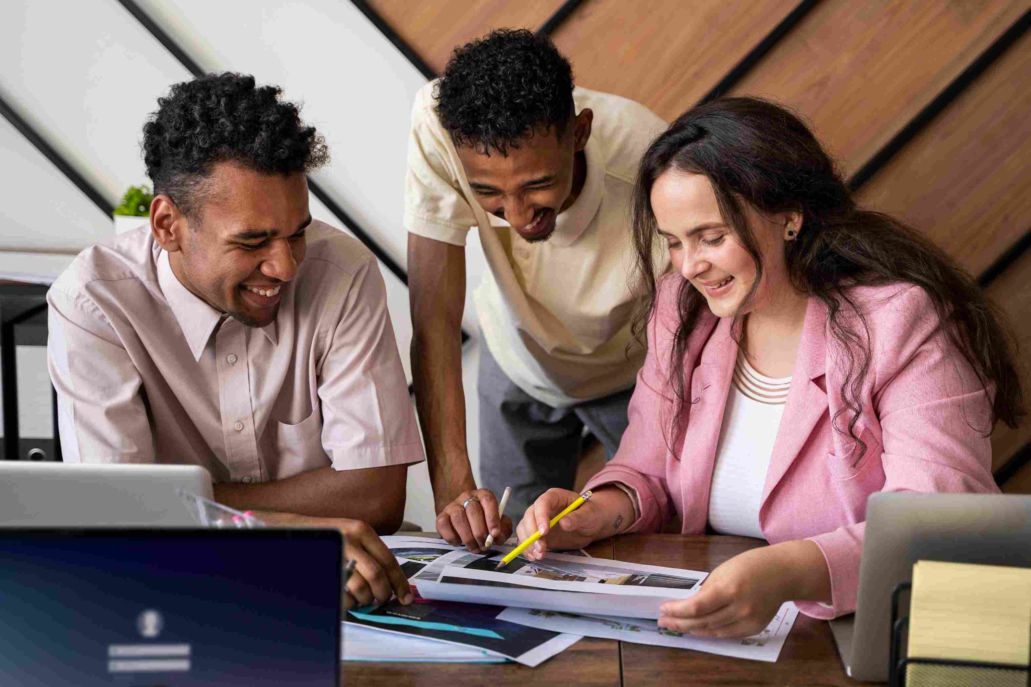 Three people looking at a document on a desk
