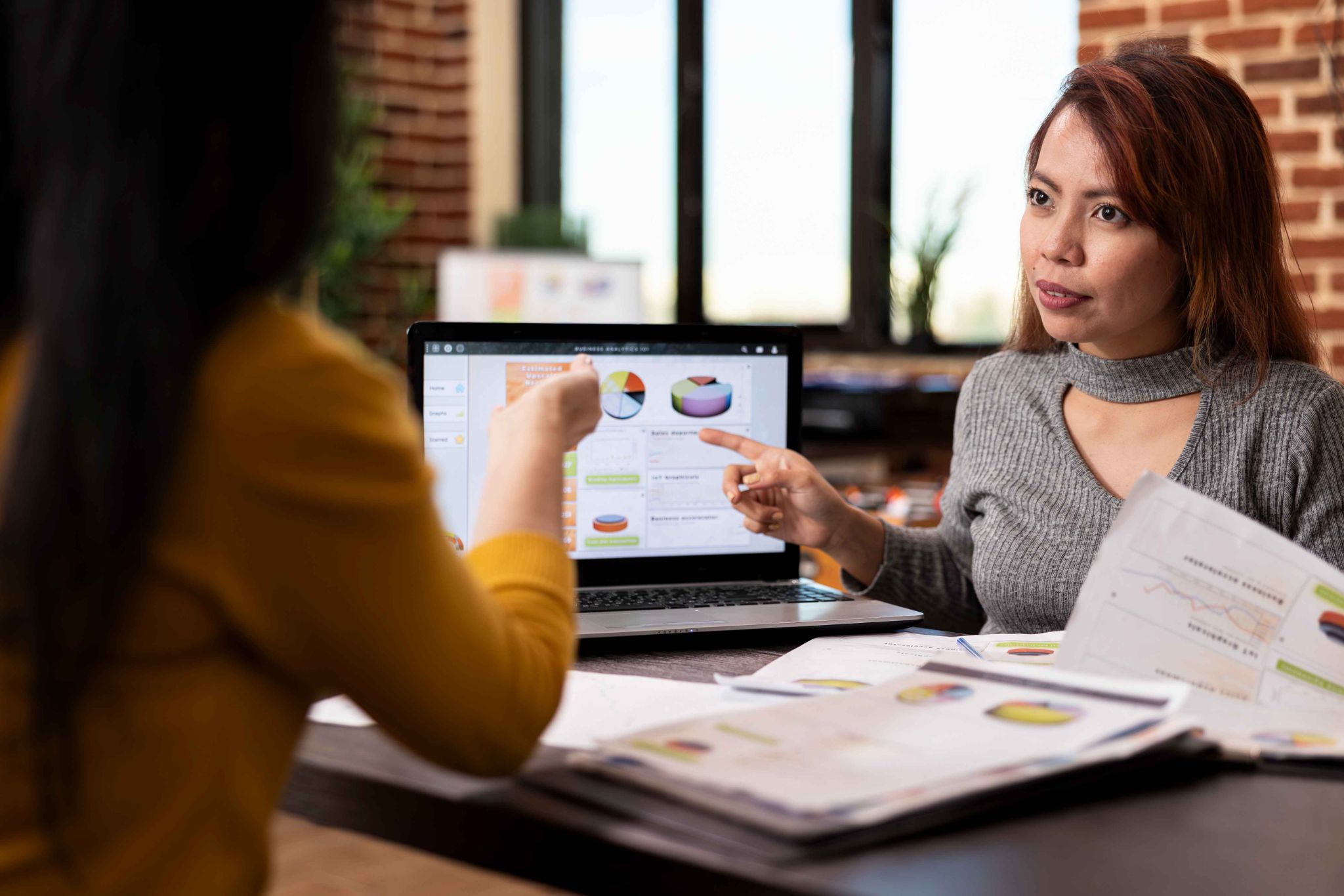 Colleagues discussing department data to spot high-risk teams