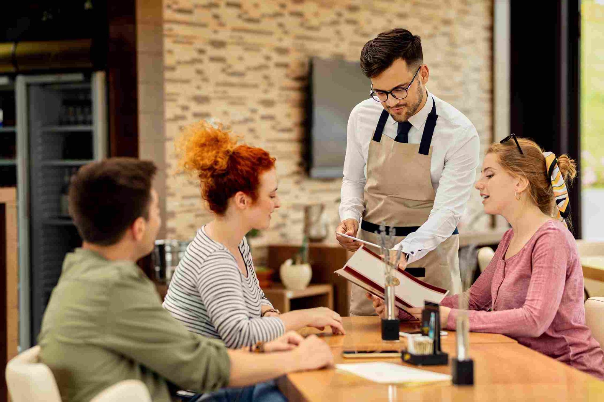 Restaurant waiter taking an order from customers