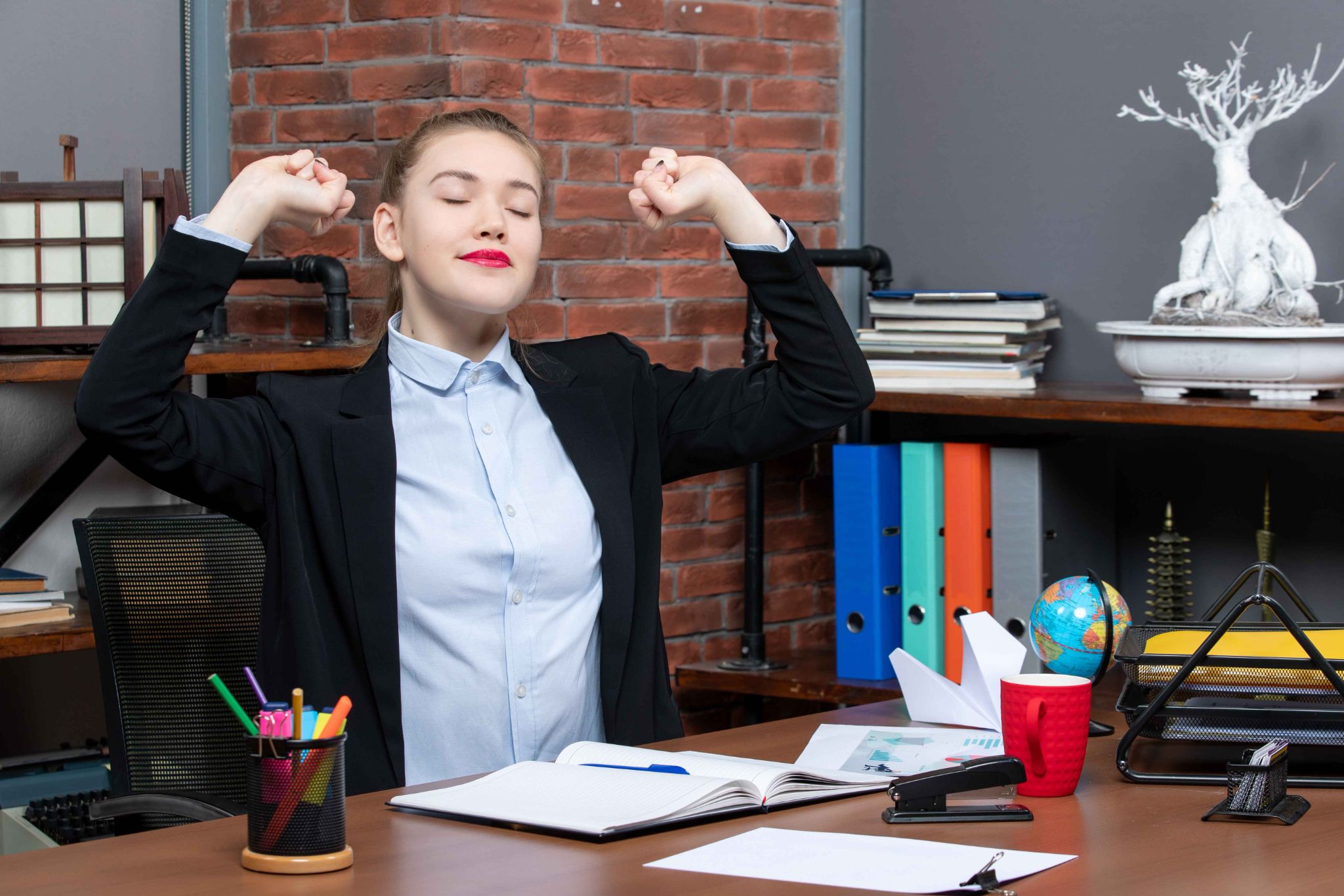 Woman stretching at desk, feeling relieved