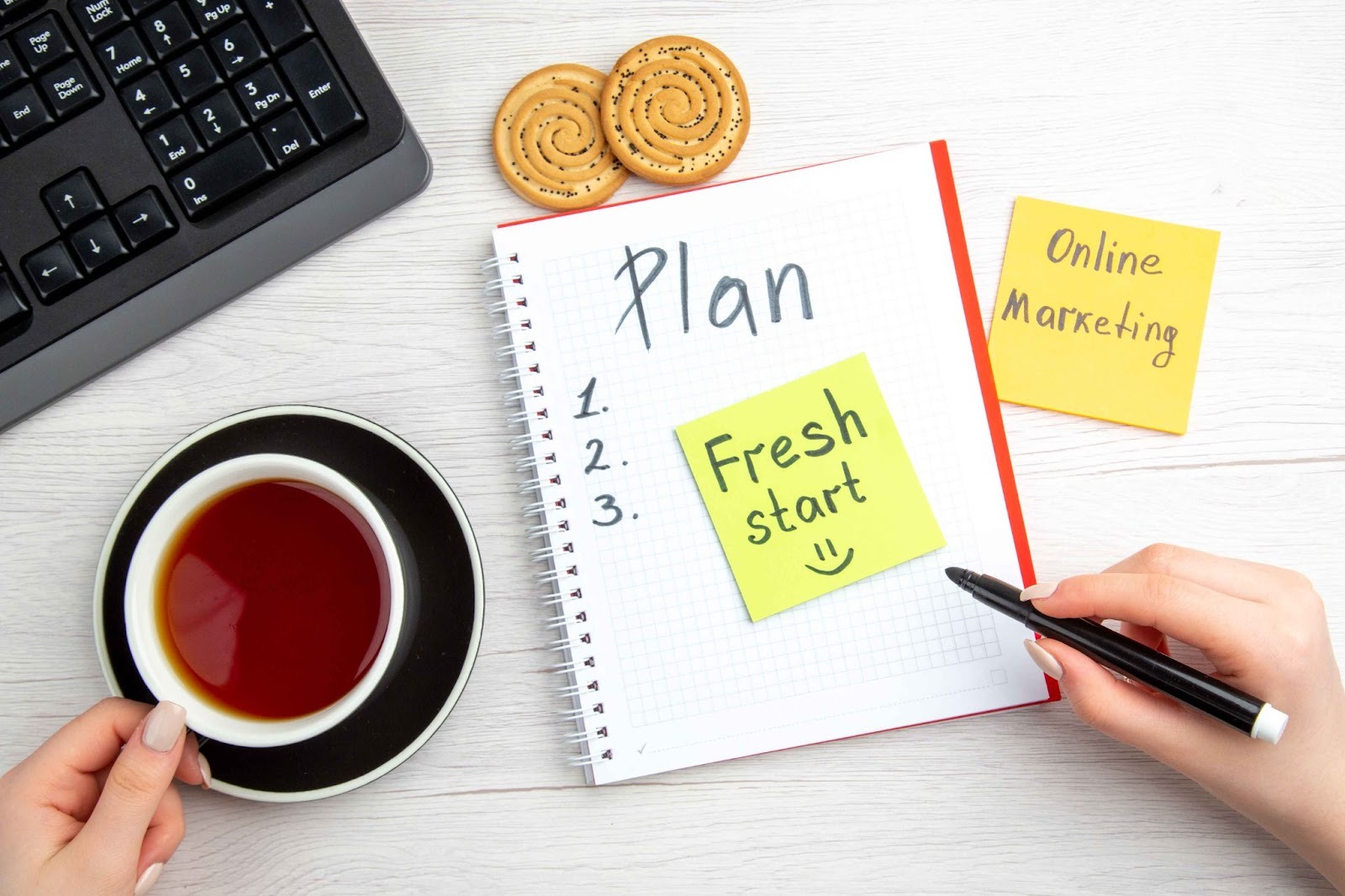 Hands writing on a notepad with Plan 1. 2. 3. Fresh start