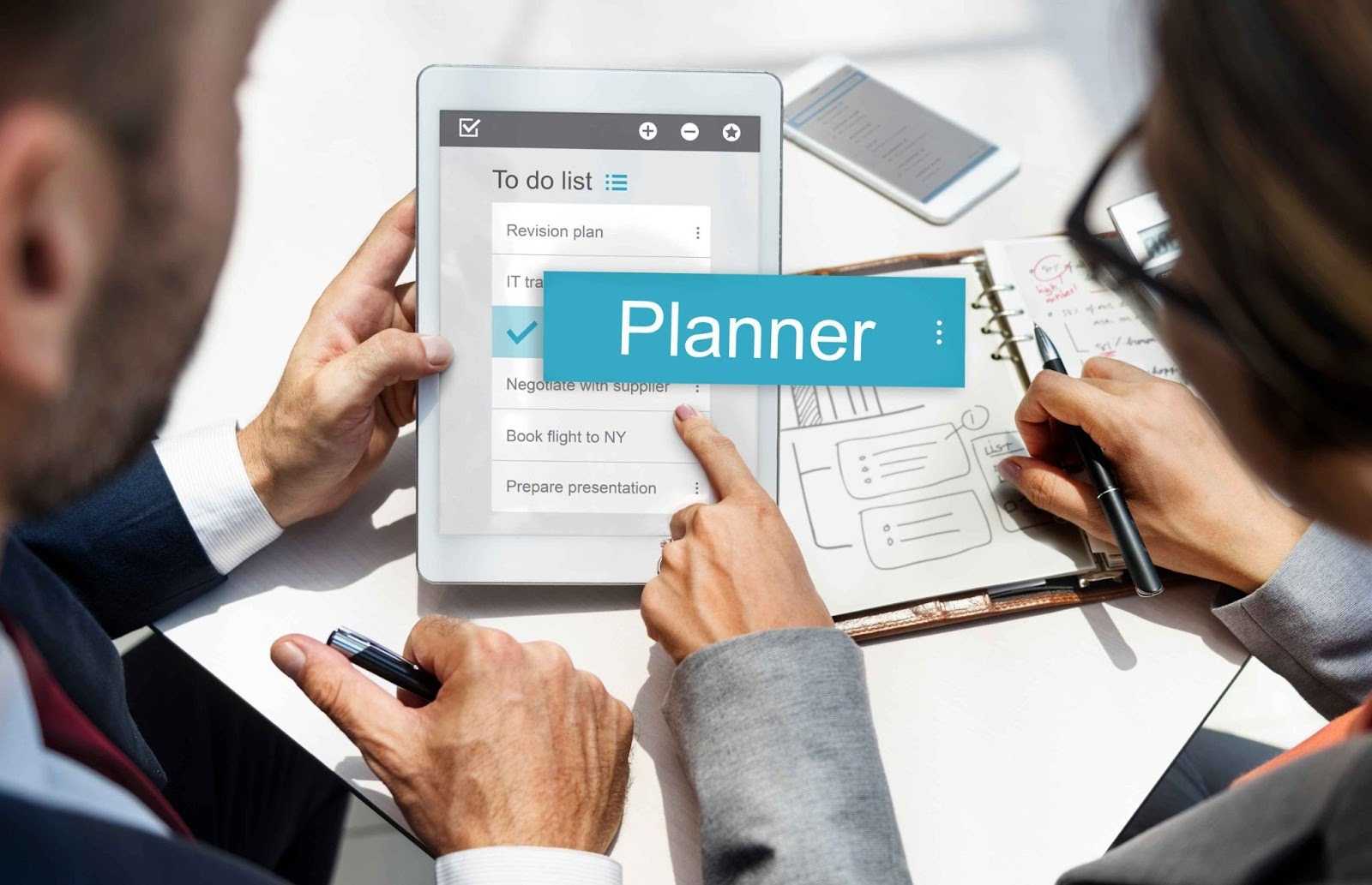 People looking at a tablet showing a Planner app