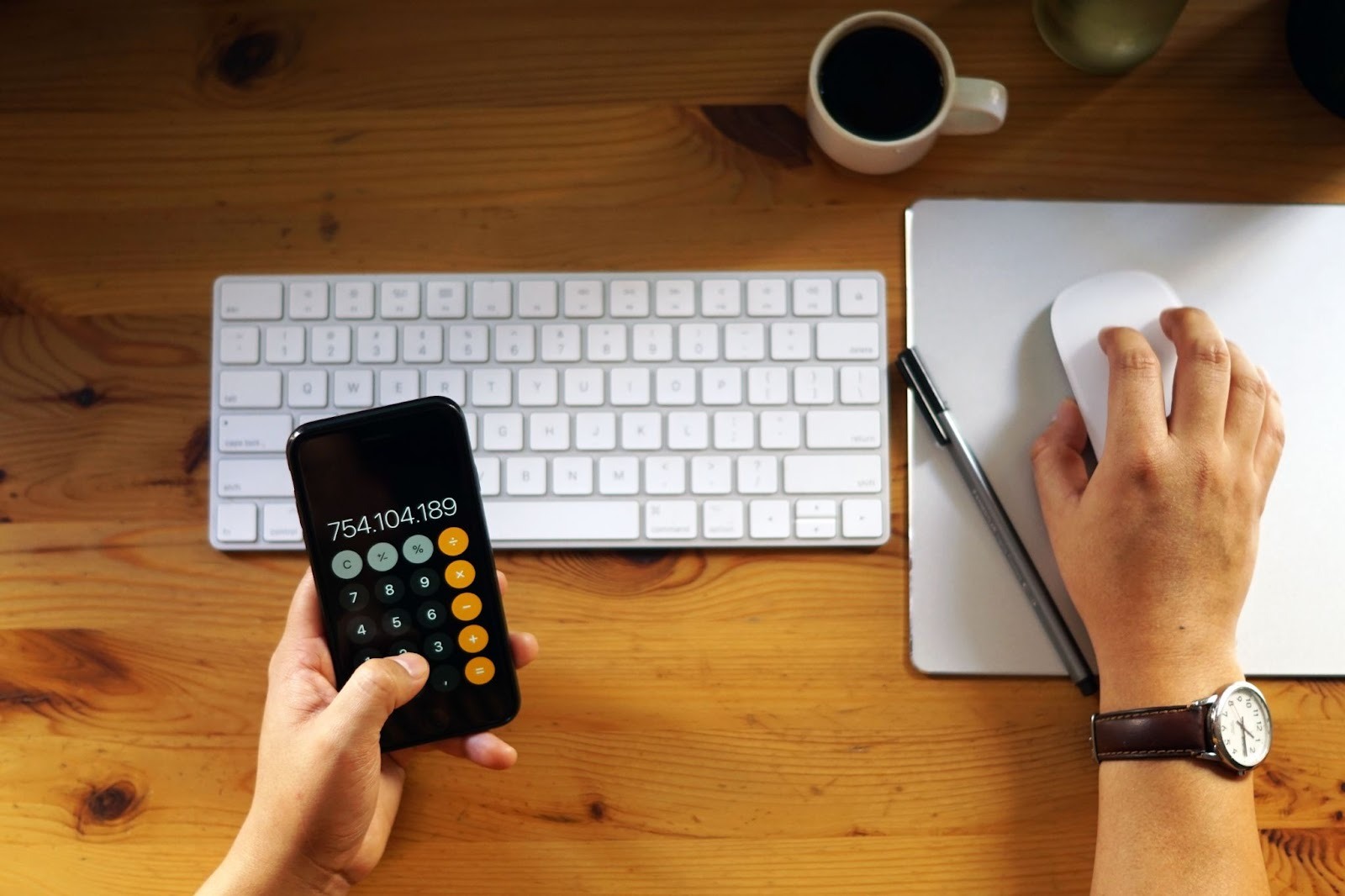 Person calculating pay with calculator and smartphone