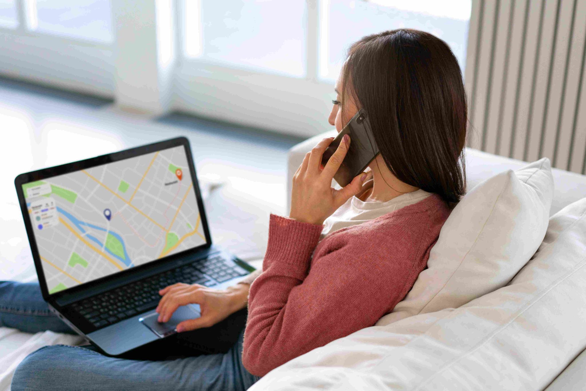 Woman looking at GPS map on laptop while on a phone call