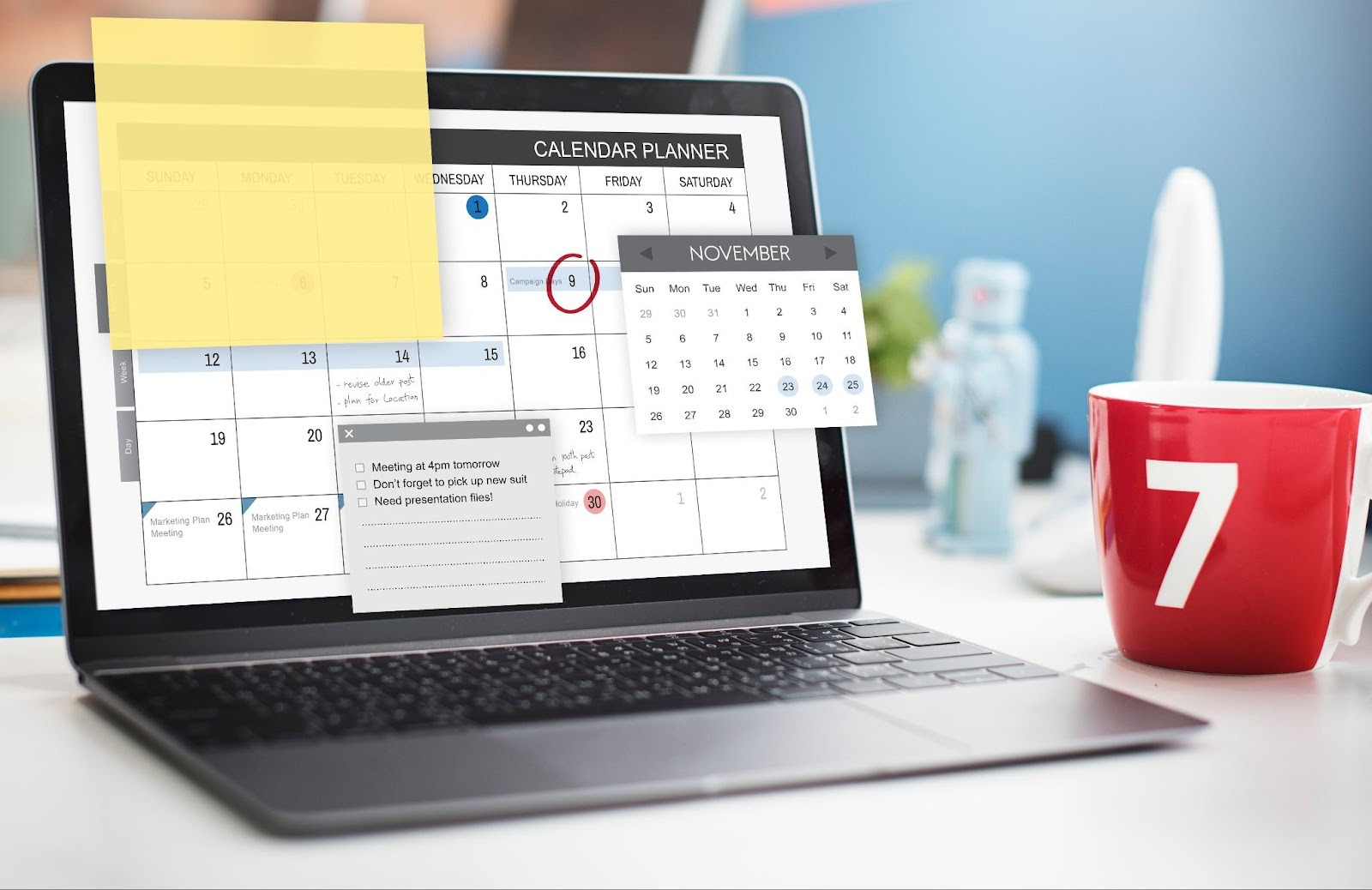 Laptop with a calendar planner on screen, coffee mug, sticky notes