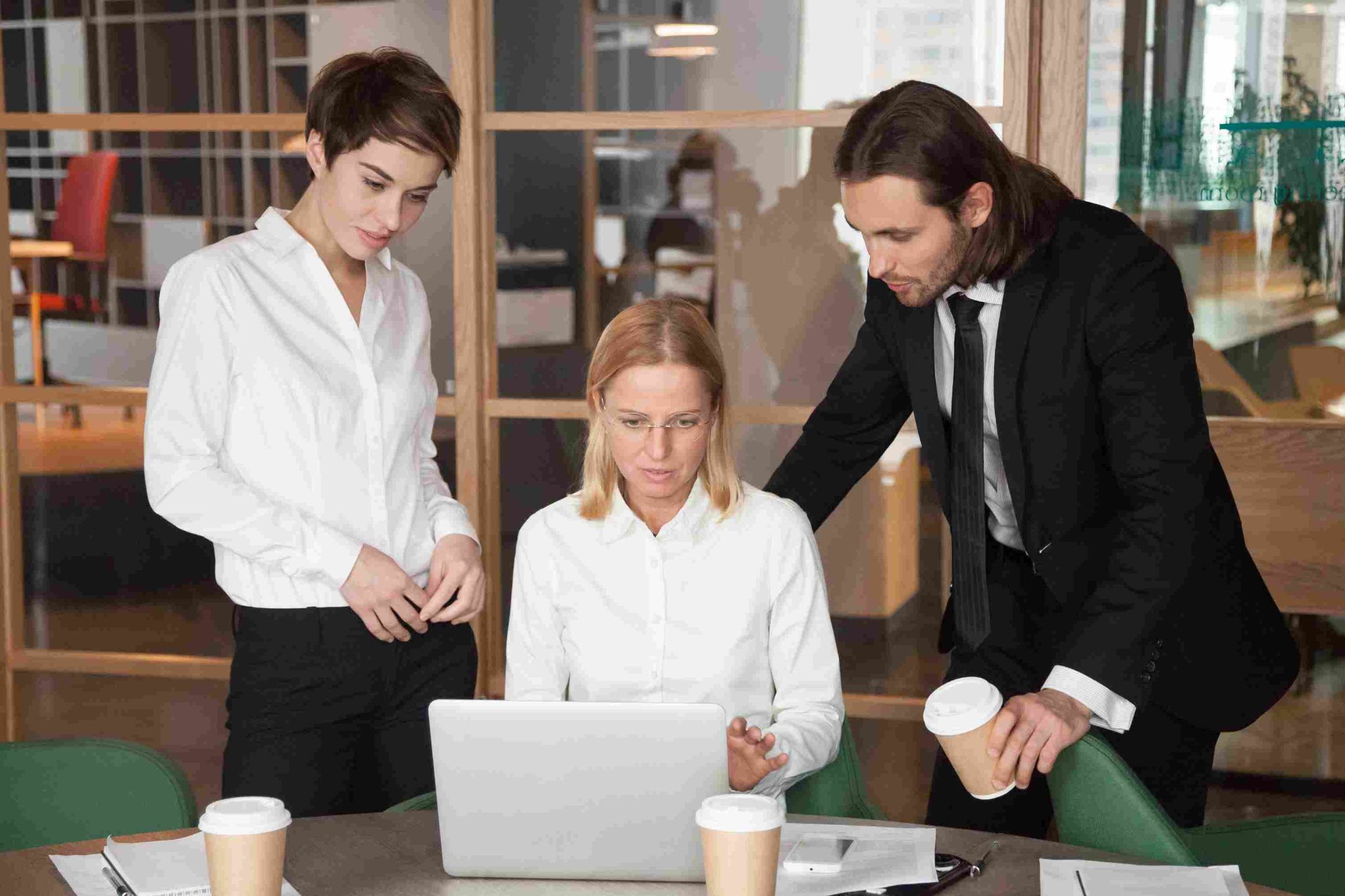Team looking at a laptop to review schedules