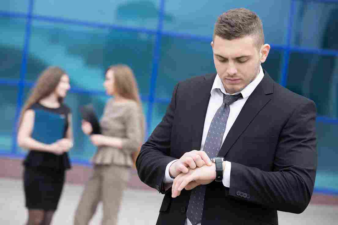 Business professional looking at his watch in a modern office environment