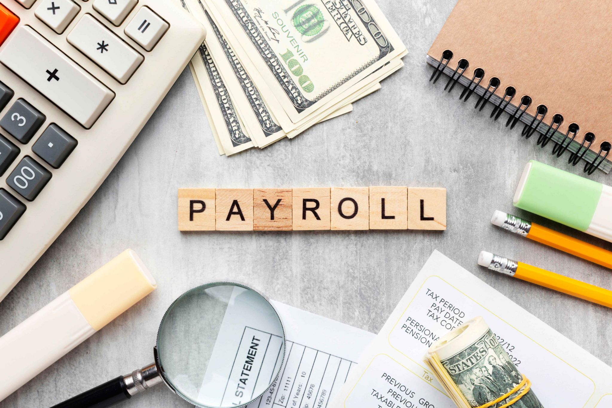 Payroll concept with wooden blocks, money, and calculator