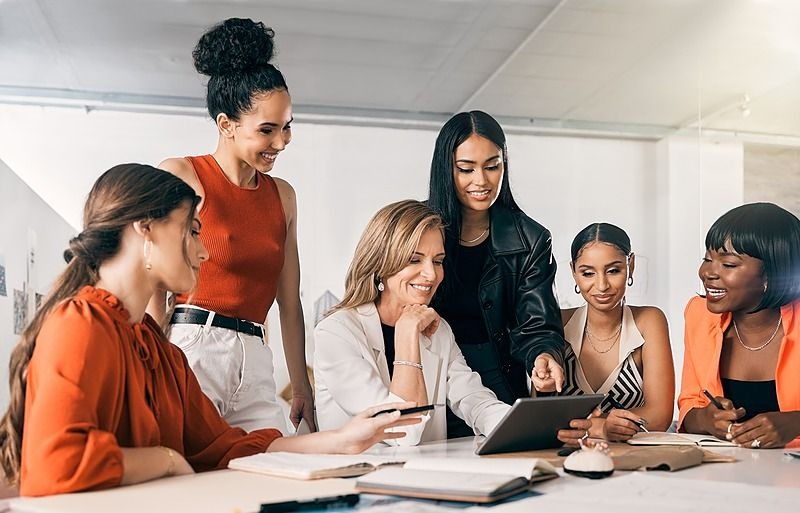 Female colleagues collaborating over a tablet in the office