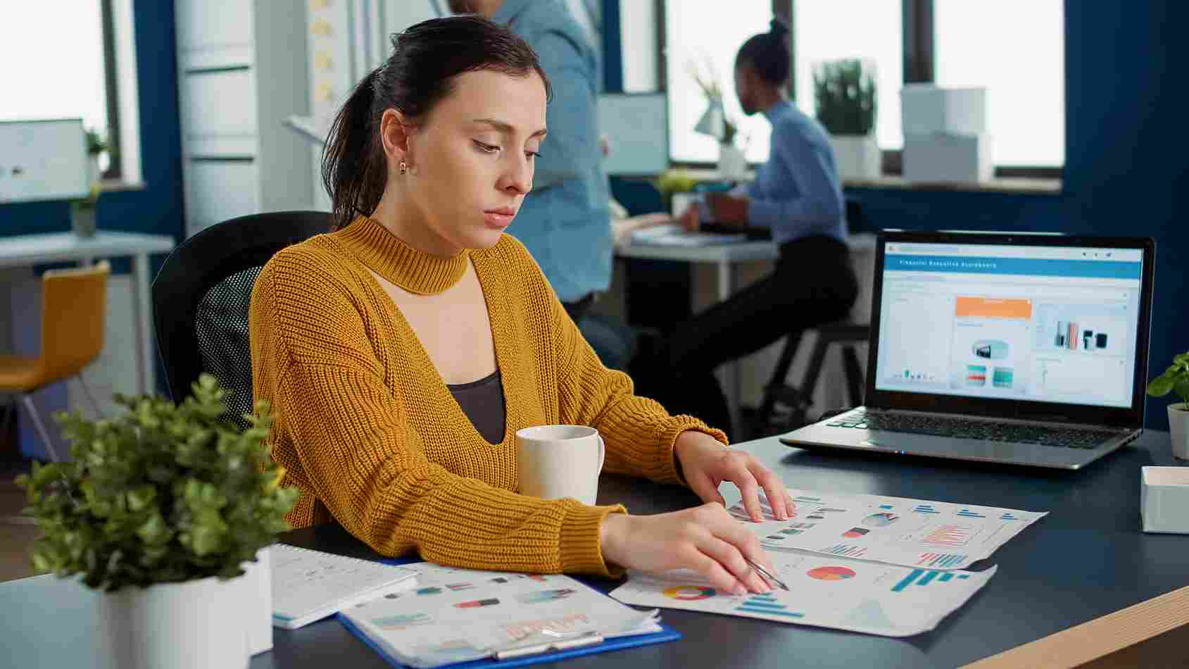 Woman looking at a laptop screen with charts
