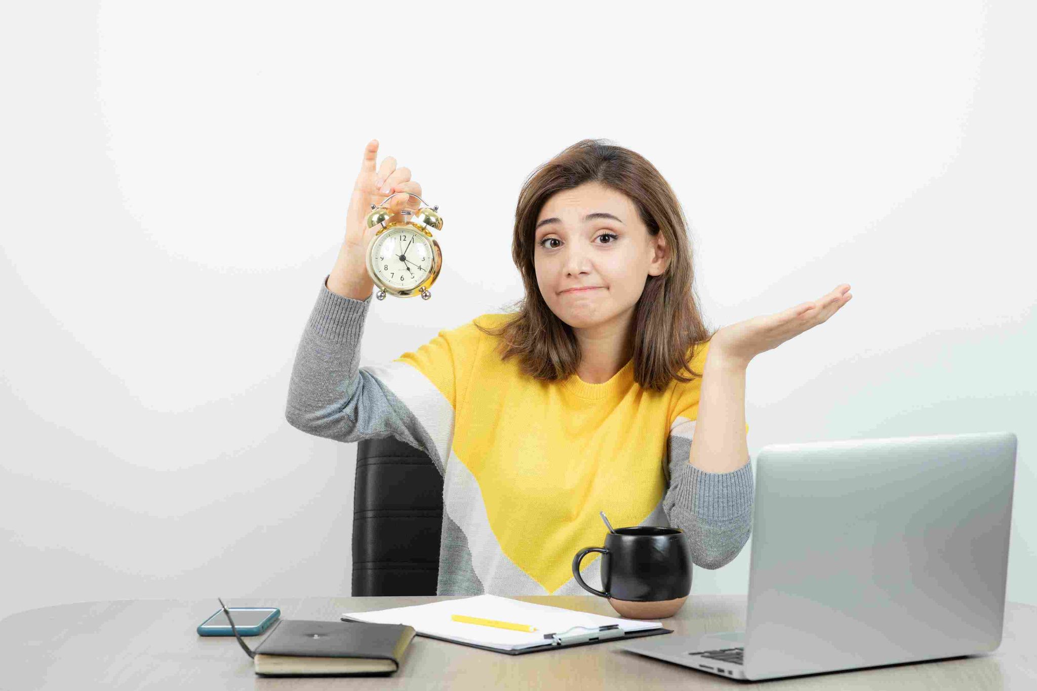 Woman holding an alarm clock, thinking about time management