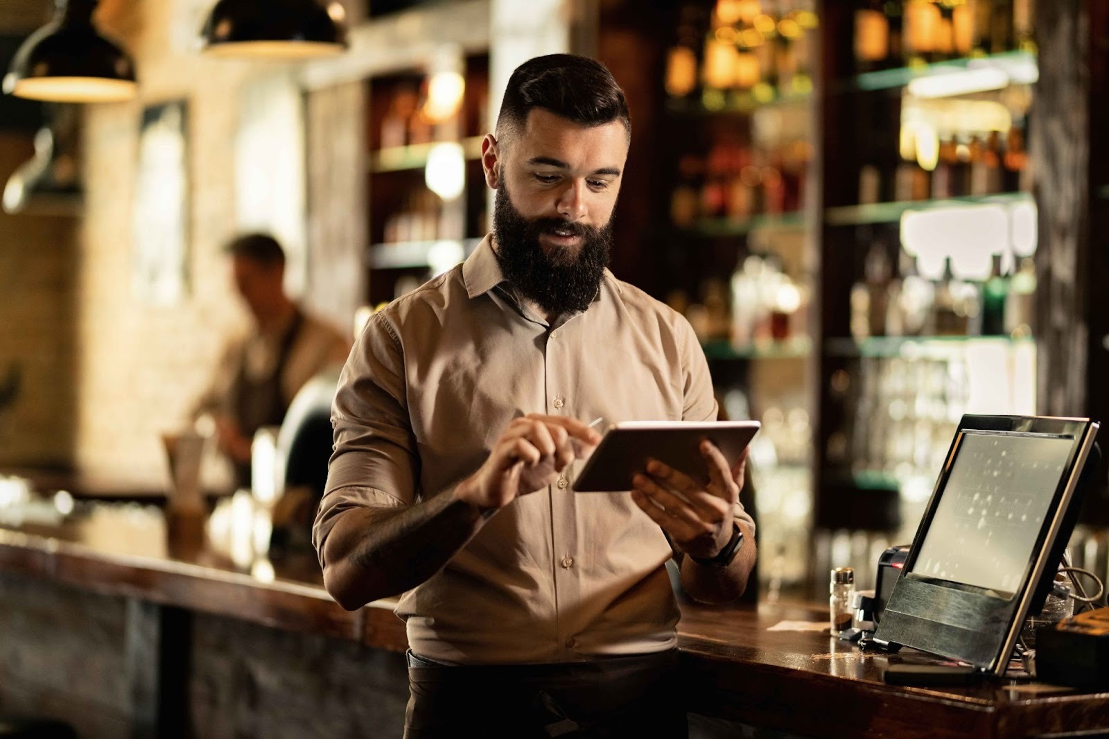 Bartender checking schedule on tablet