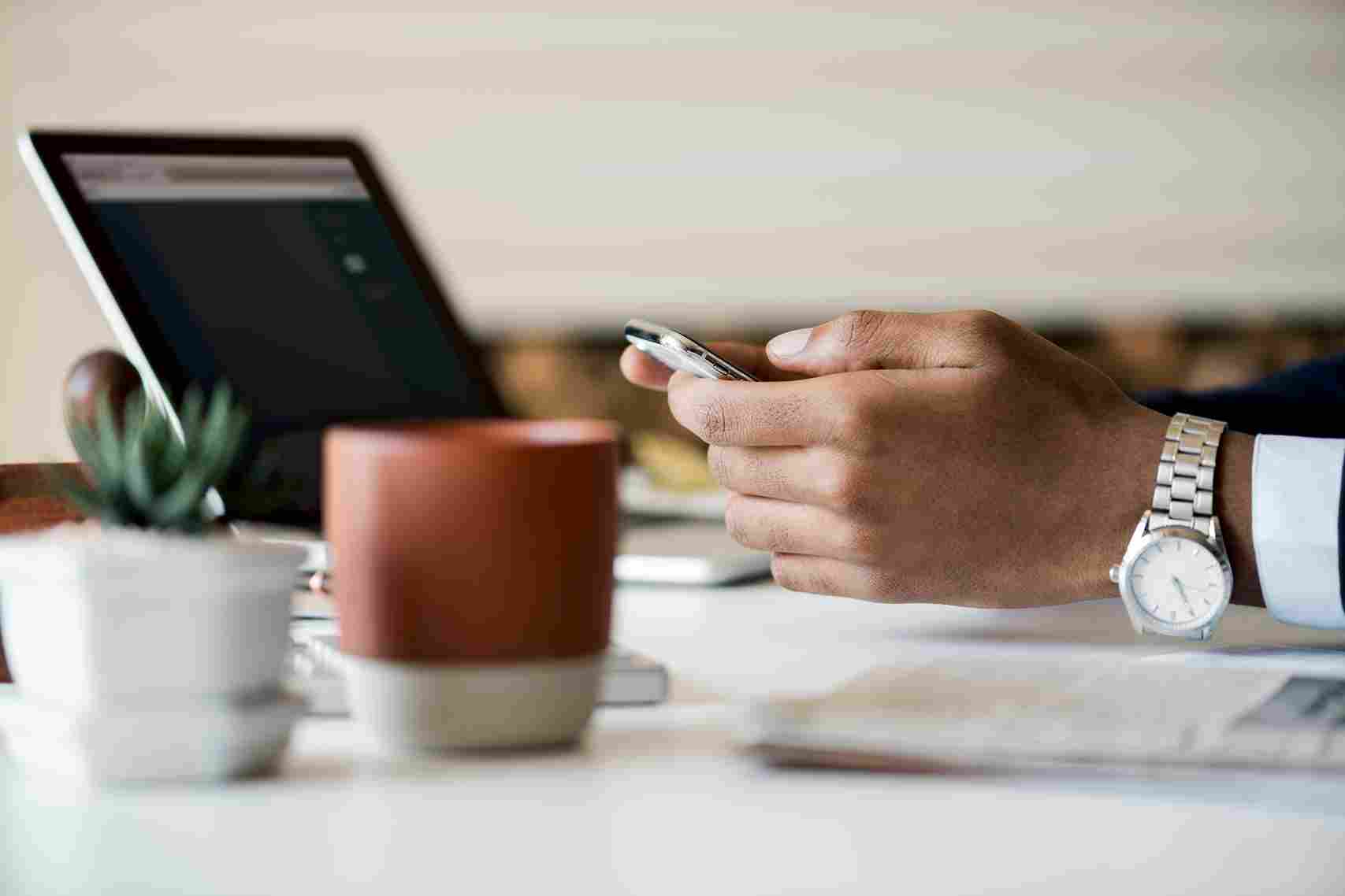Person using a tablet and smartphone at a desk