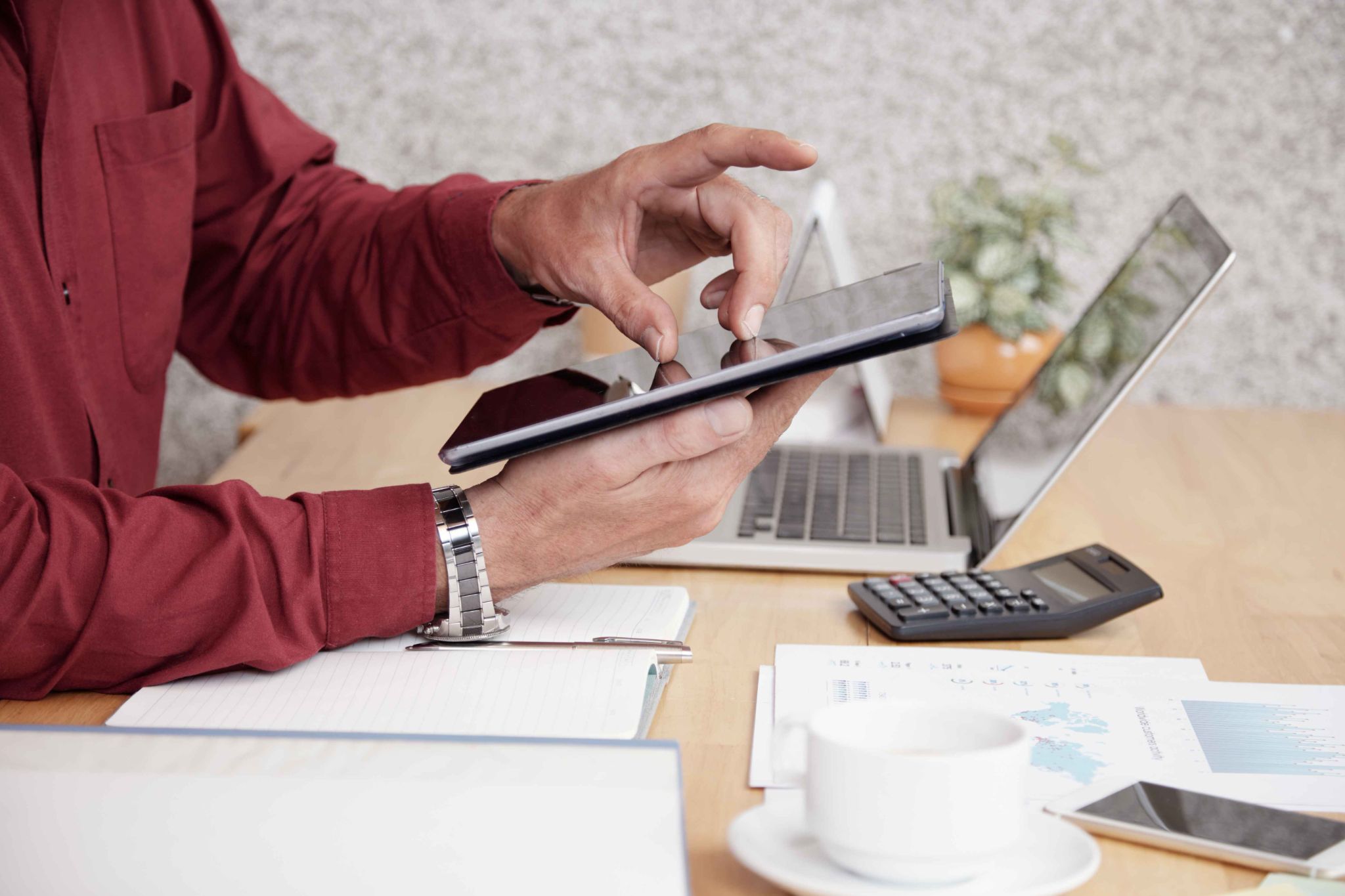 Employee using tablet and laptop for attendance tracking and accountability