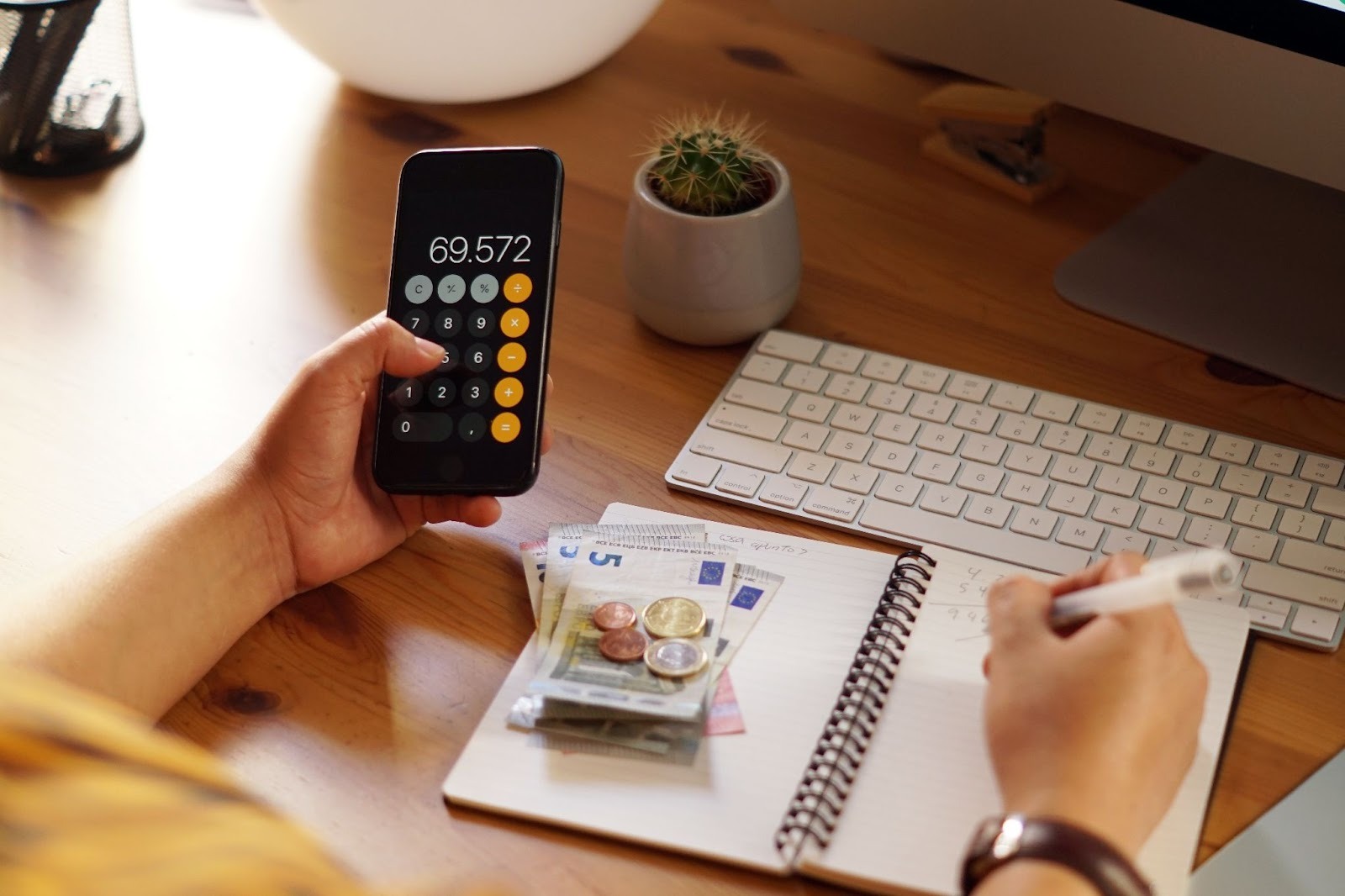 Person reviewing finances with a phone and calculator