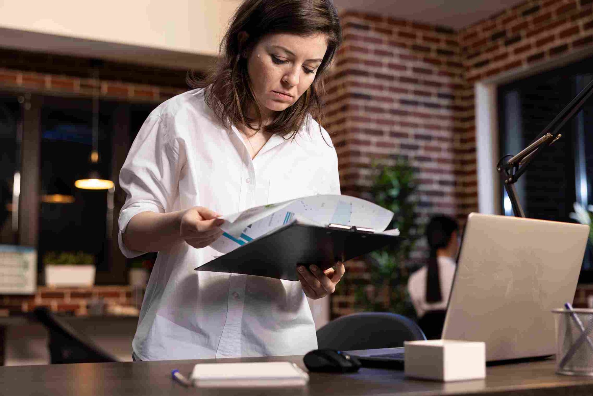 Woman looking at a clipboard in an office setting