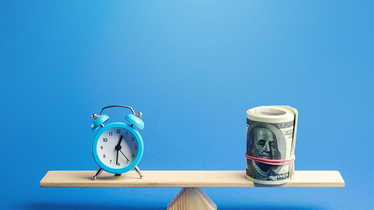 Clock and money on a balance scale representing time and payroll