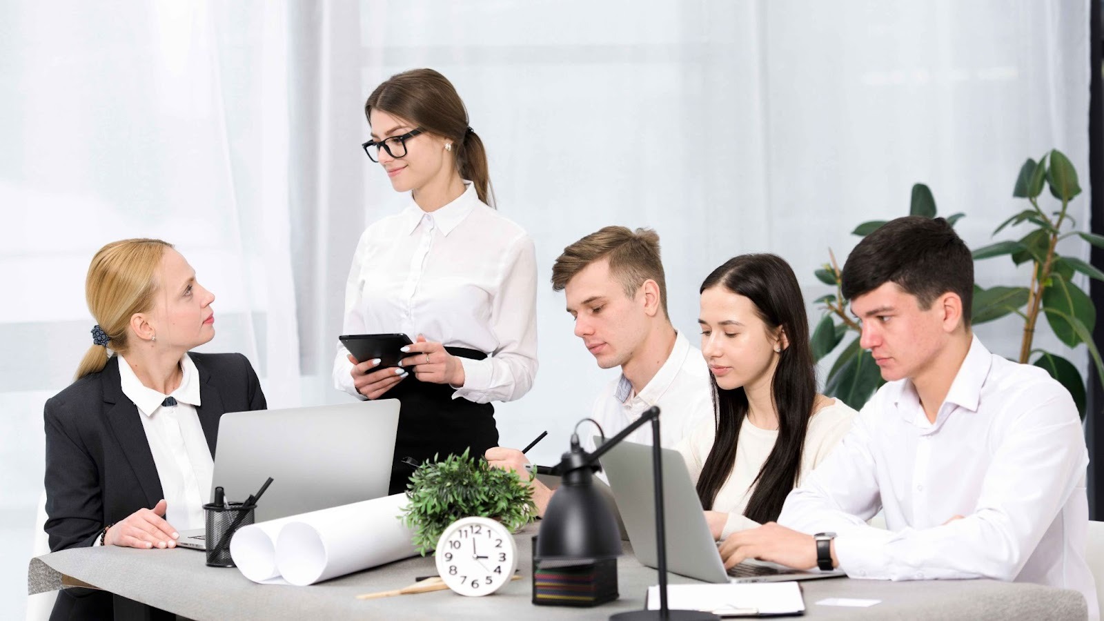Team collaborating around a laptop on a desk