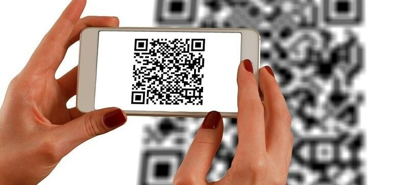 Hands holding a smartphone scanning a QR code