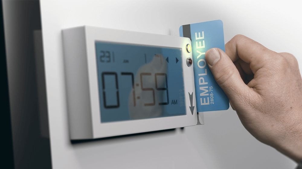 Employee using ID card on a digital time clock