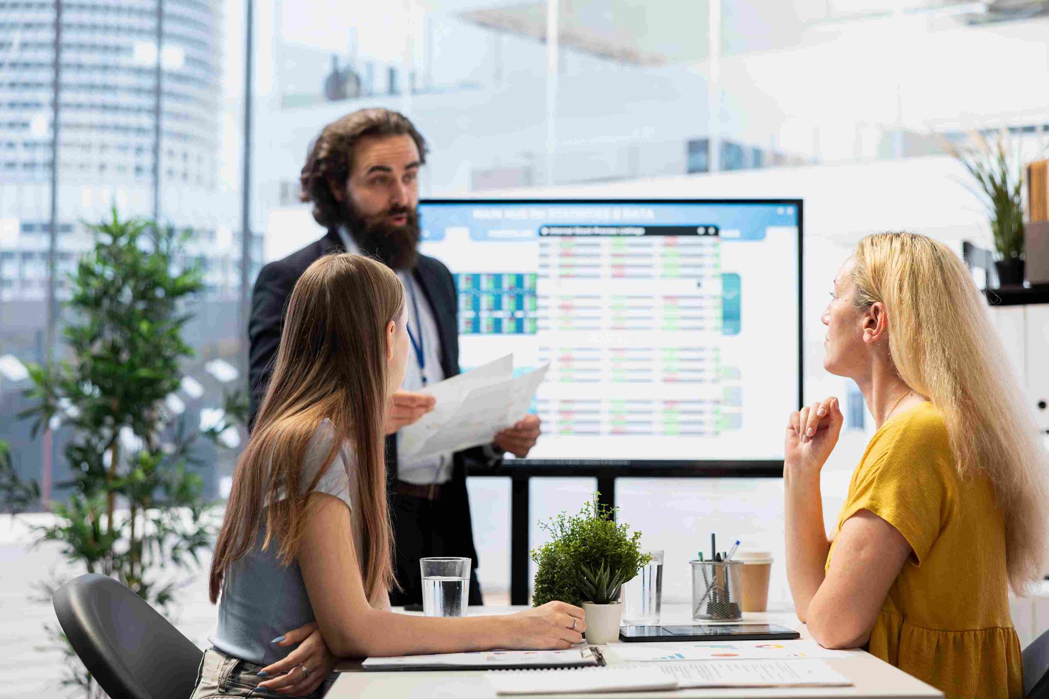 Three people in an office looking at a monitor