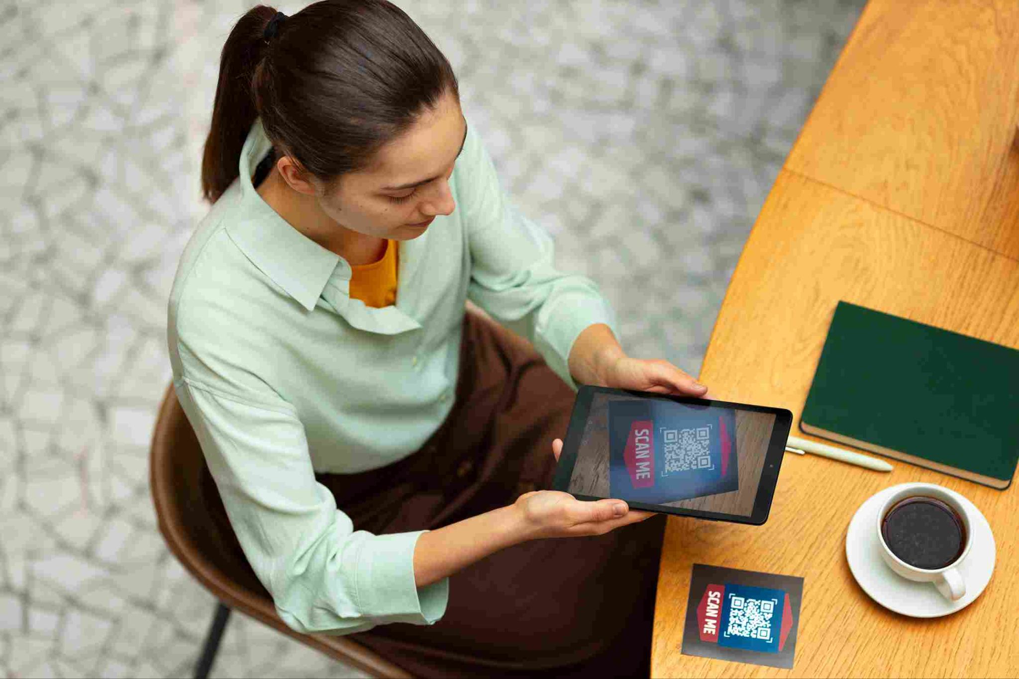 Person holding a tablet with a QR code on the screen