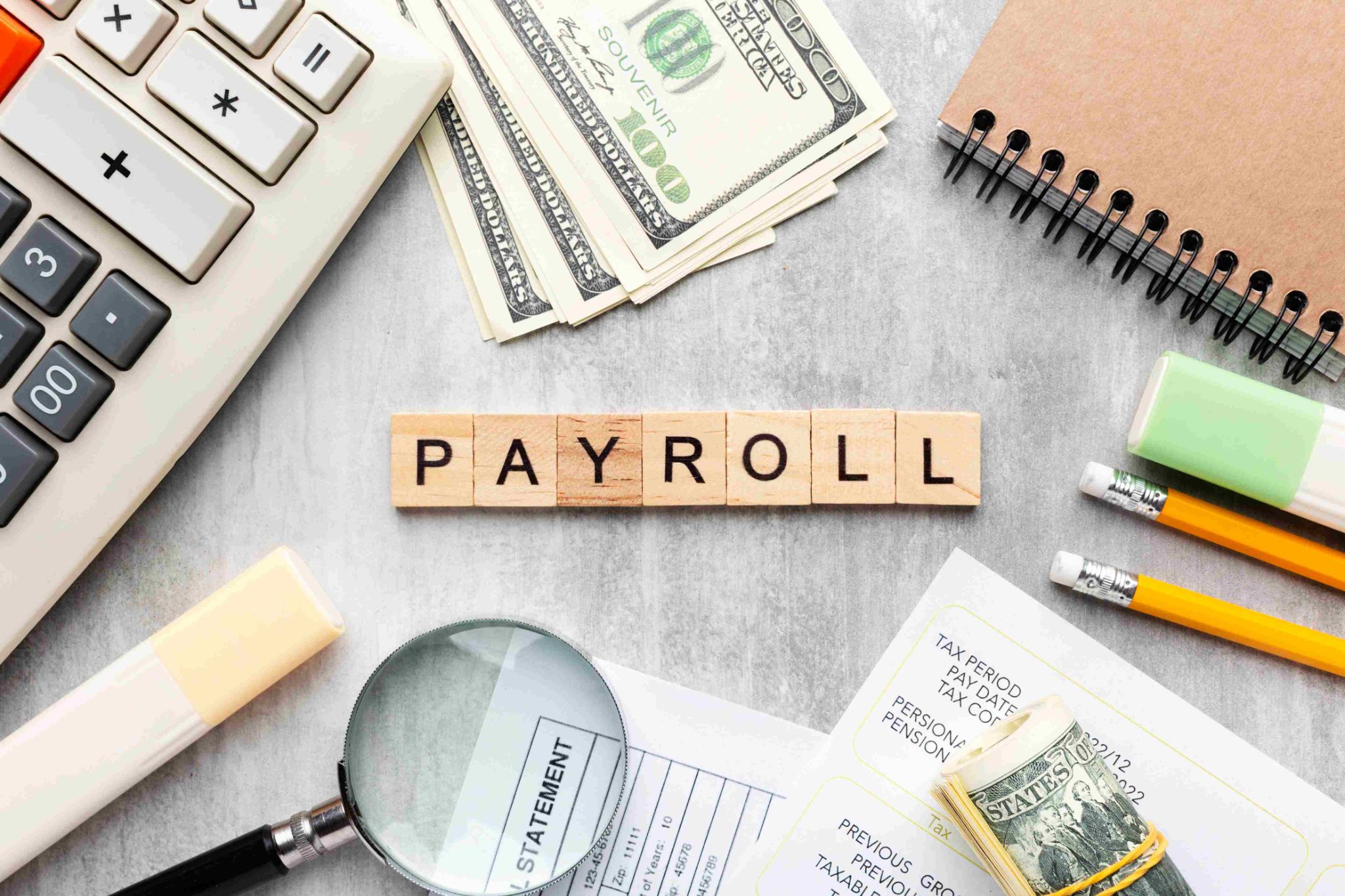 Payroll blocks with magnifying glass and money