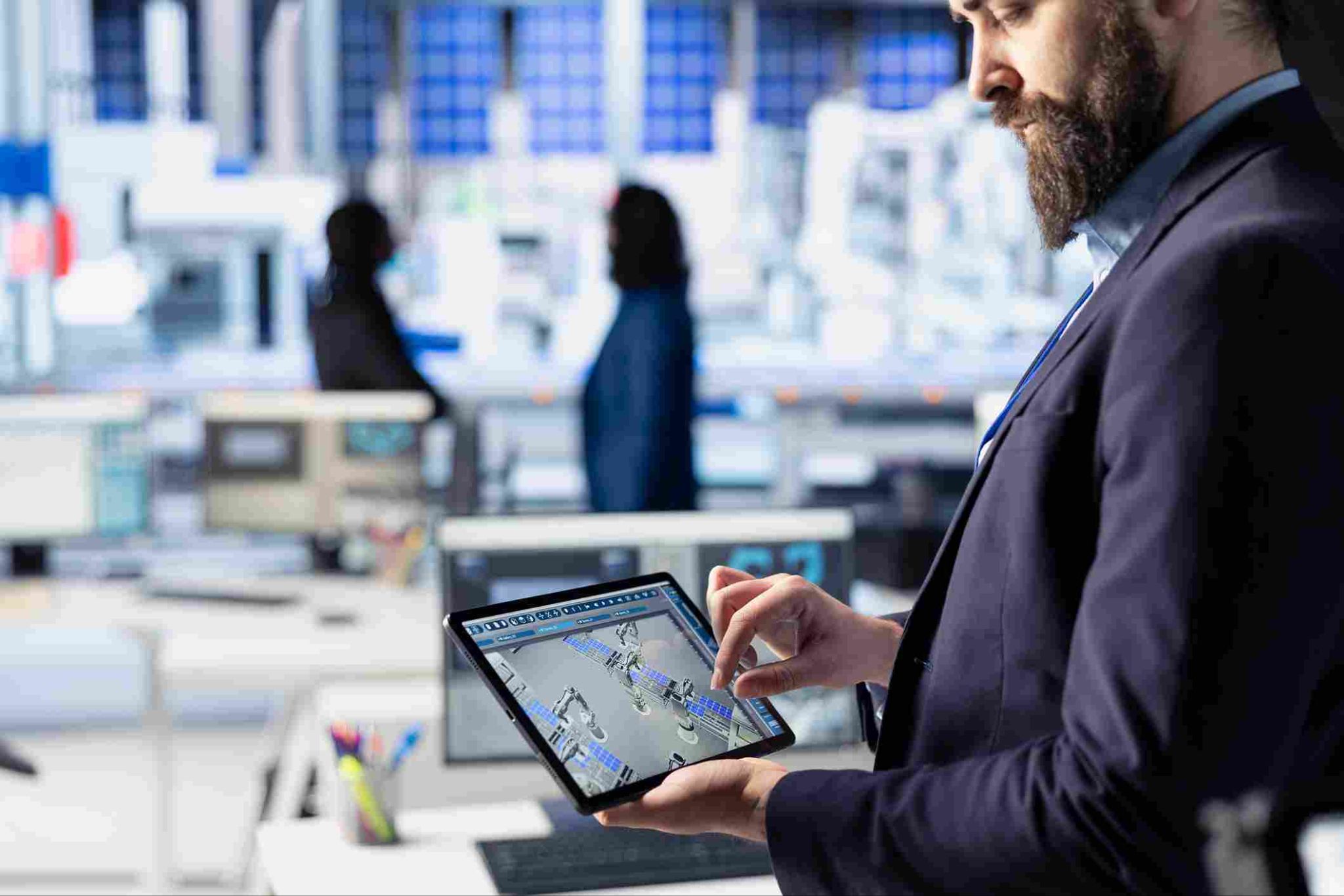 Man in a suit looking at a tablet showing a dashboard, with people walking in the background