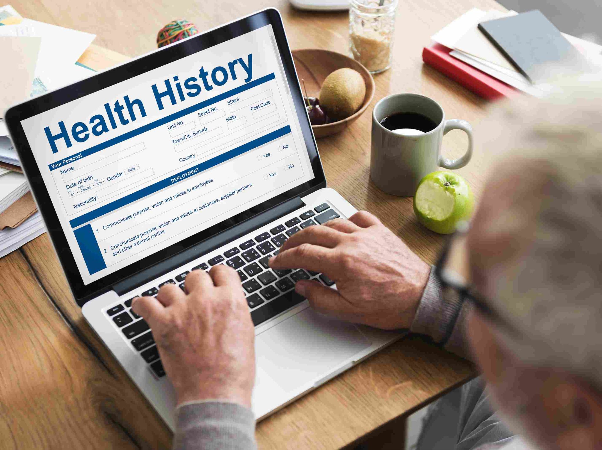 Person typing on a laptop showing a Health History screen