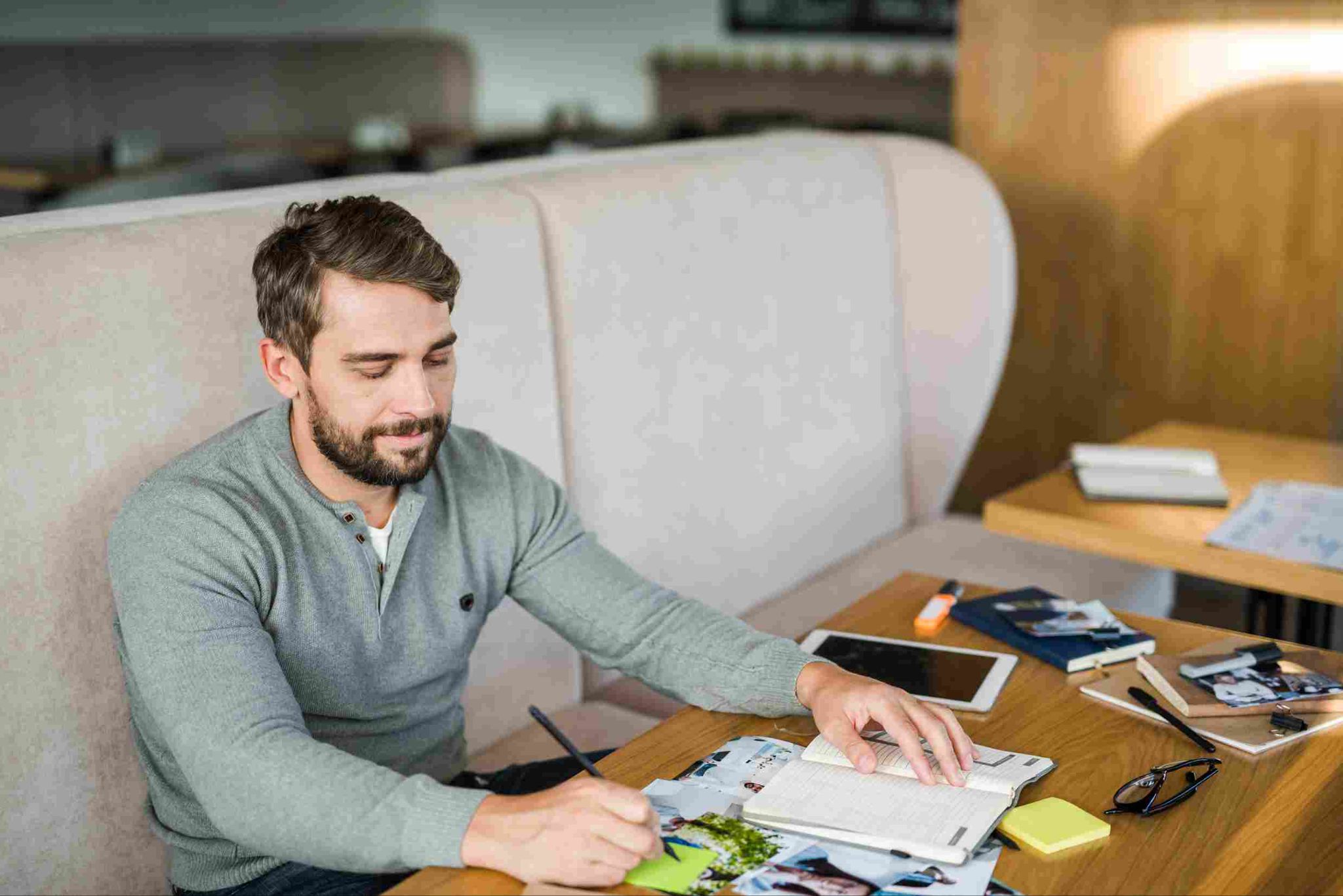 Man working at a desk reviewing documents and tablet