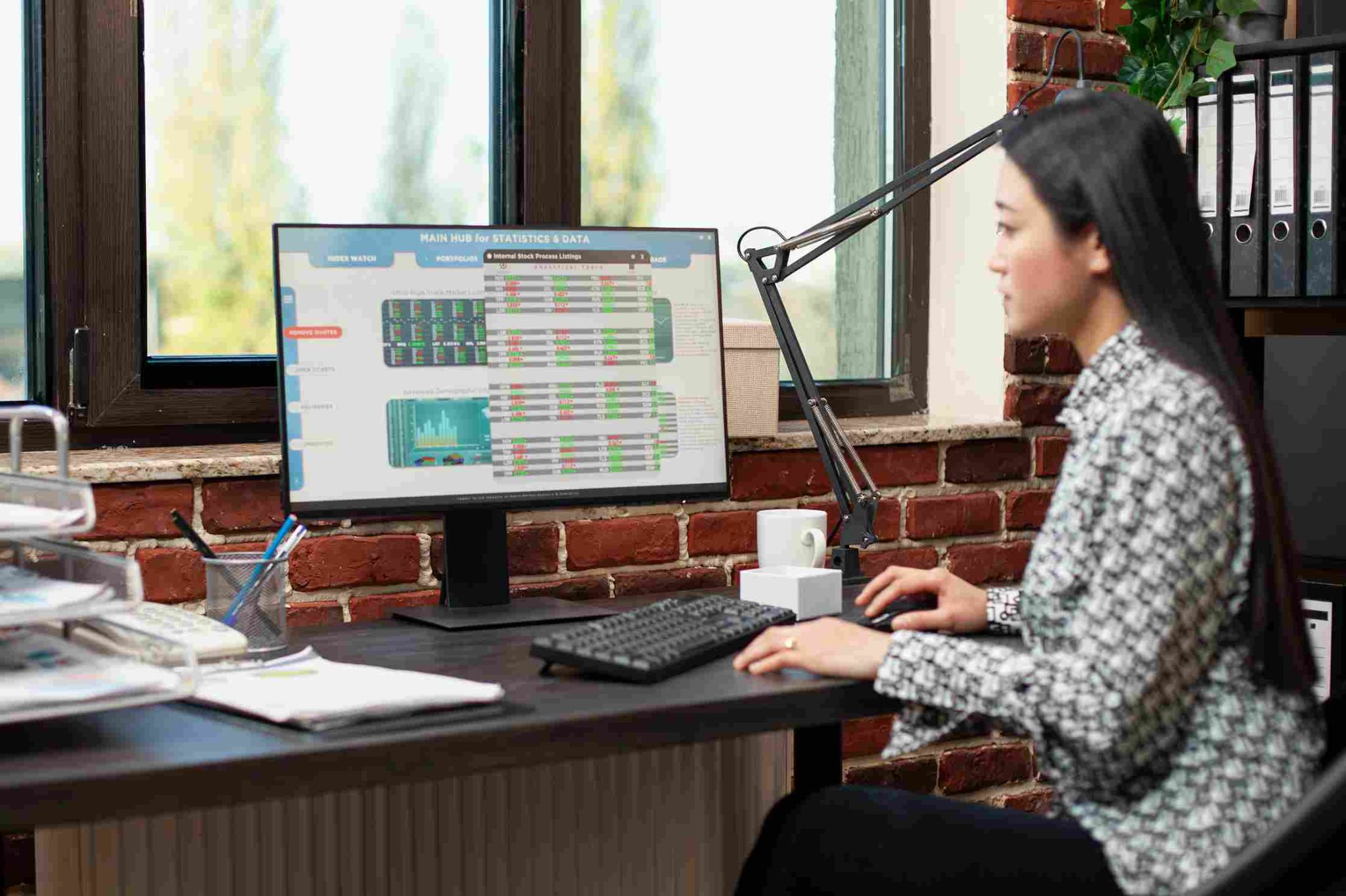 Woman working on a desktop computer viewing project data