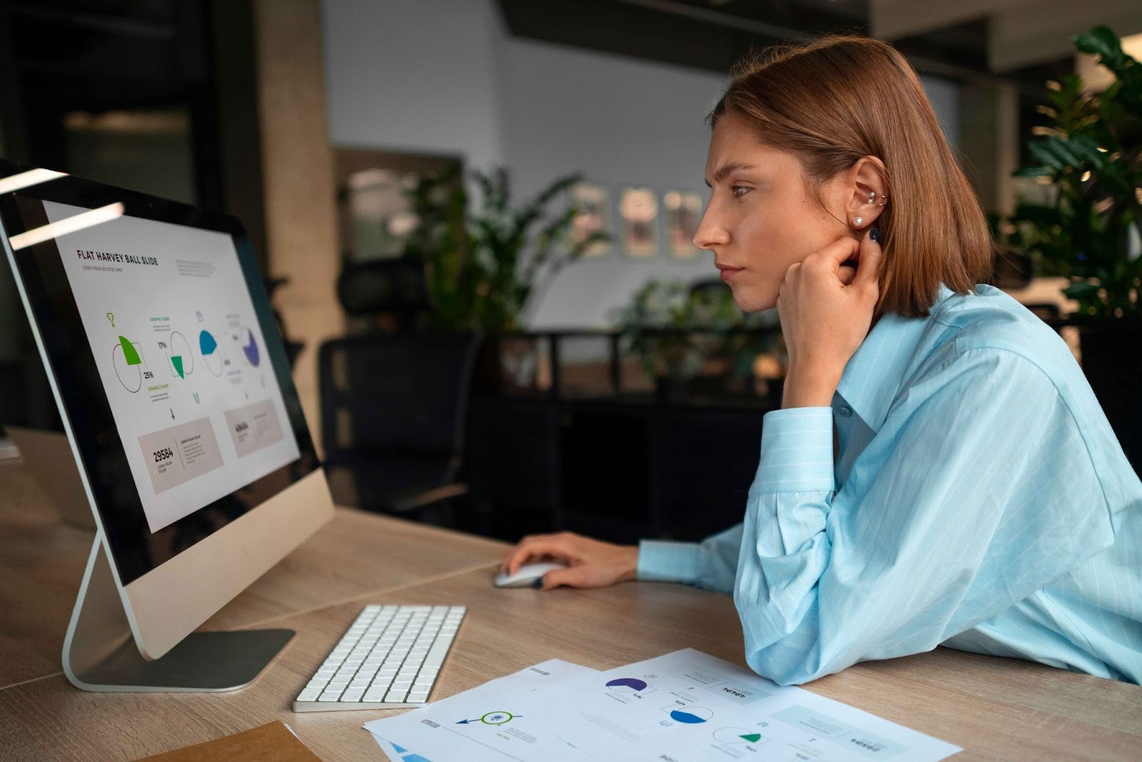 Woman working on a computer showing charts and graphs