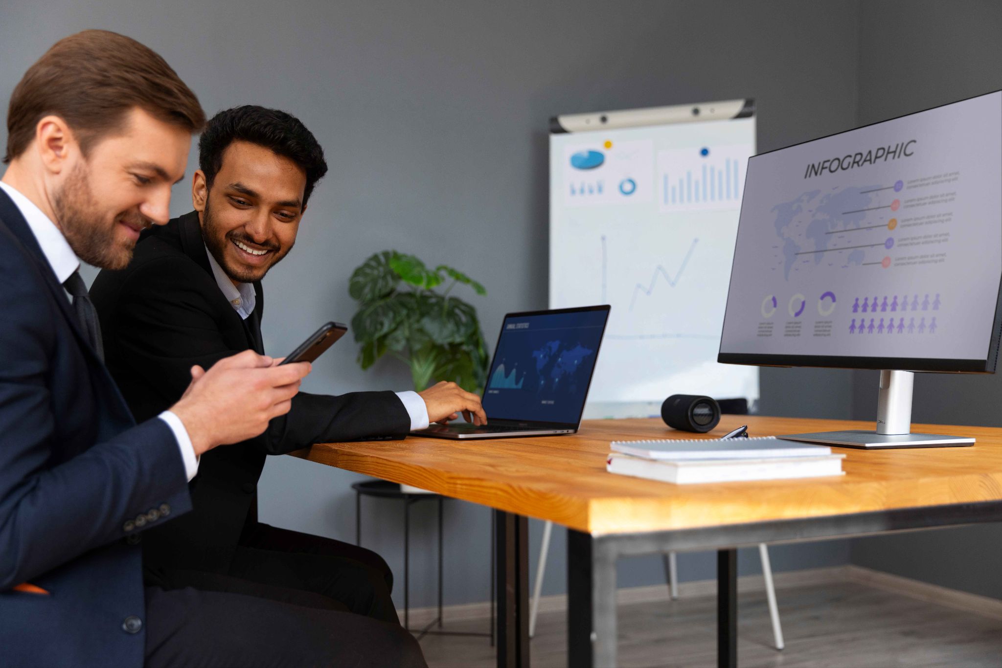 Two men looking at an infographic on a desktop monitor