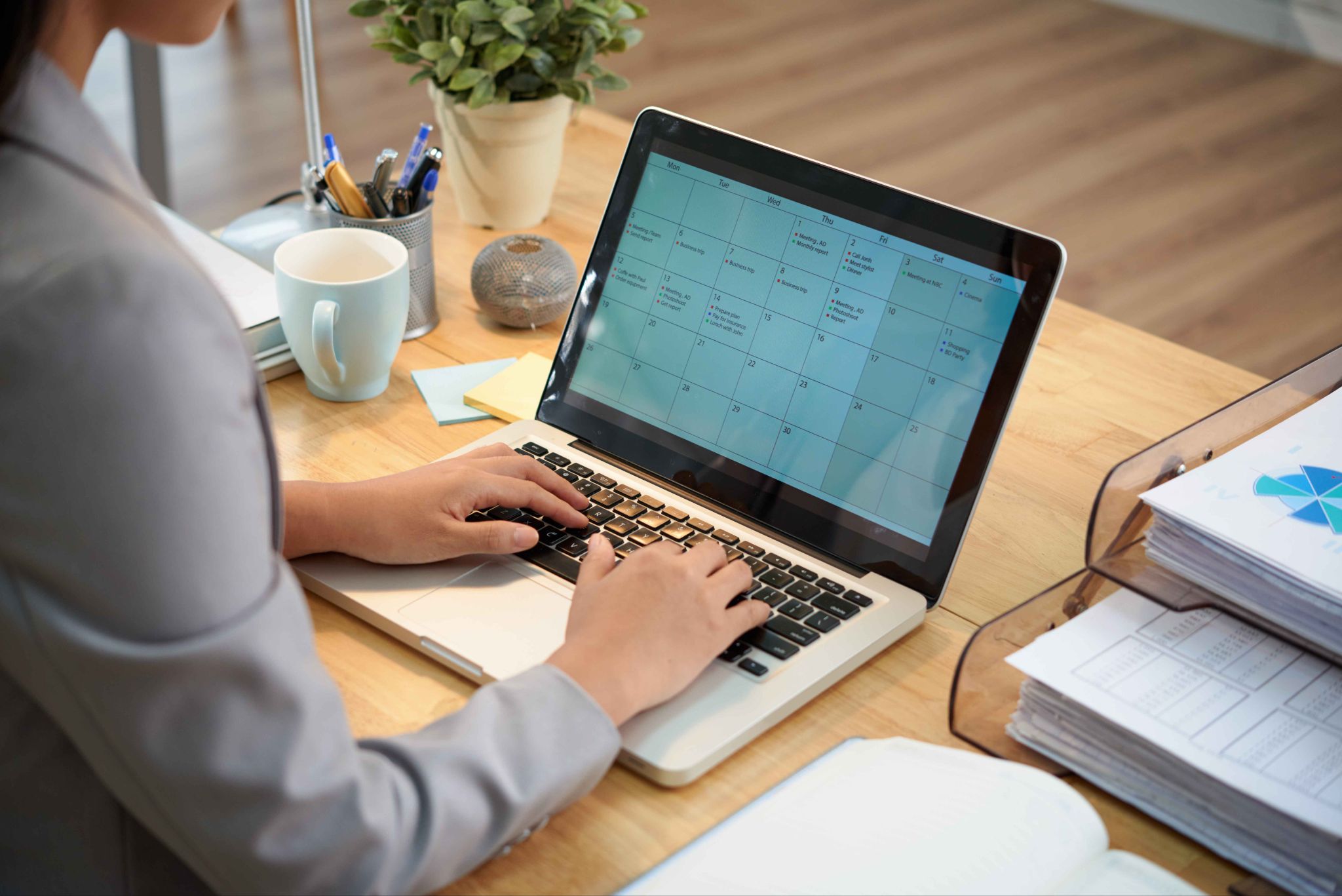 Person working on a laptop with a calendar view open