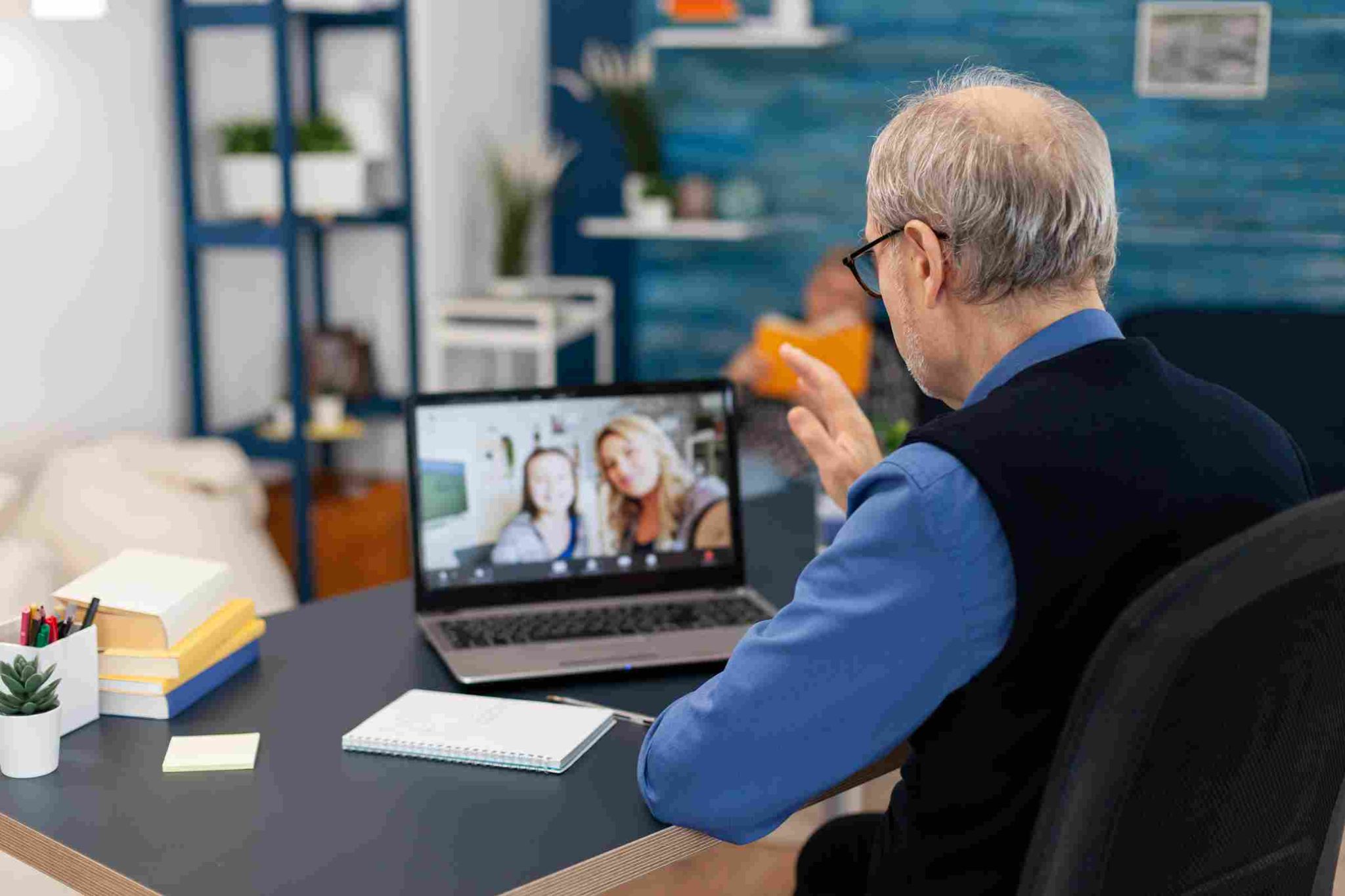 Older man working remotely on a laptop video call