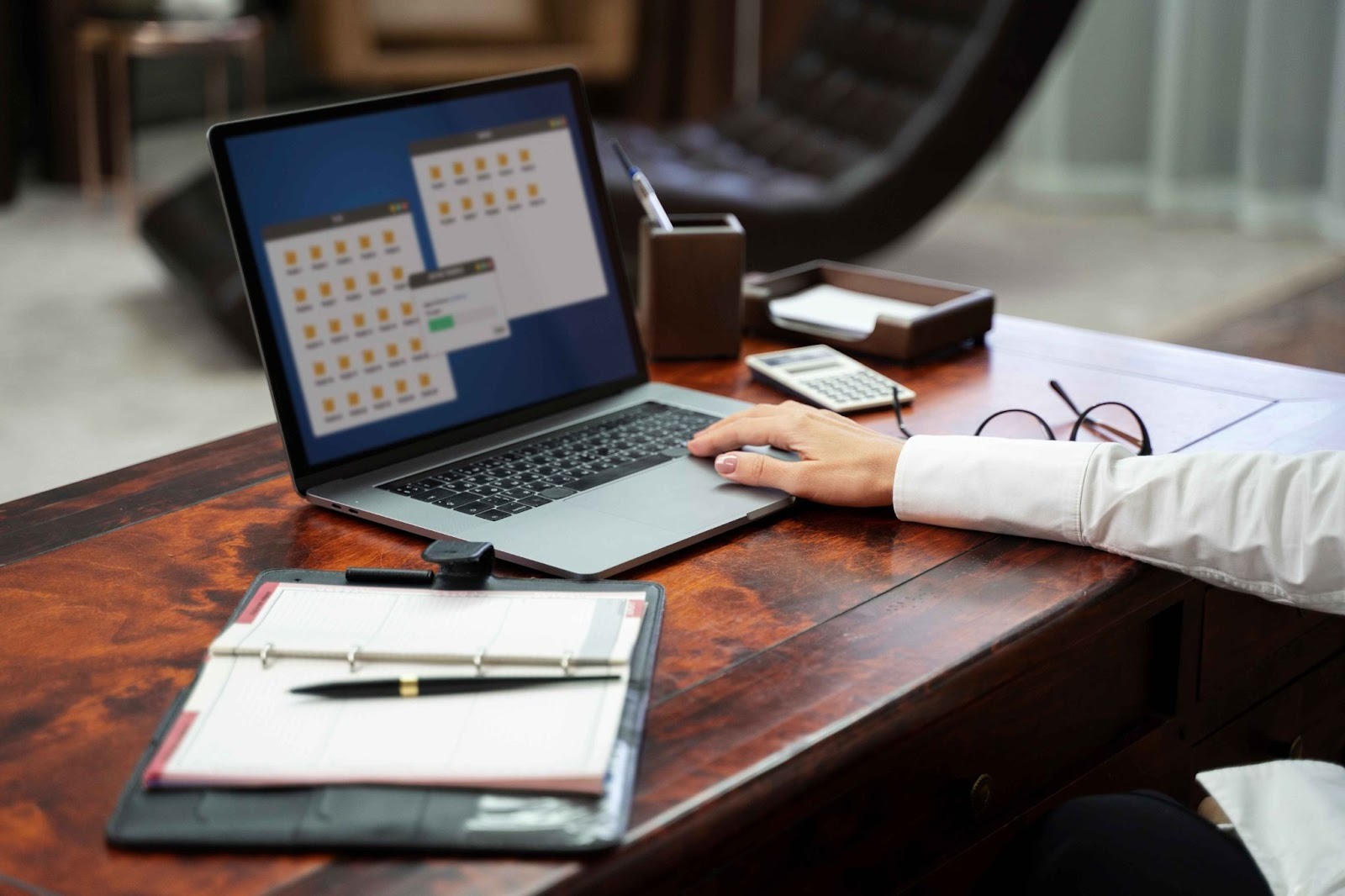 Laptop, notebook, and glasses on a desk