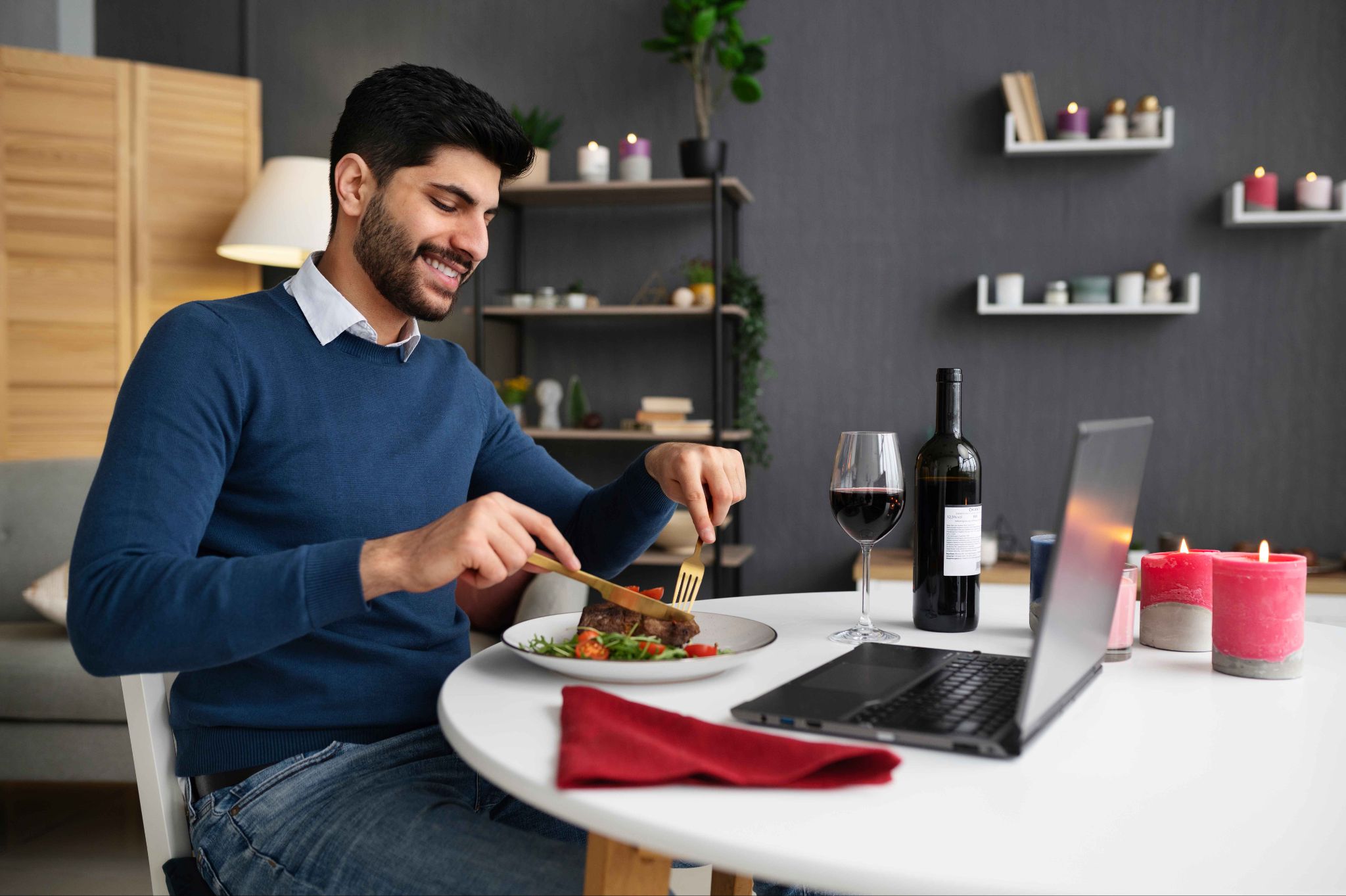 Employee eating lunch while looking at phone and laptop