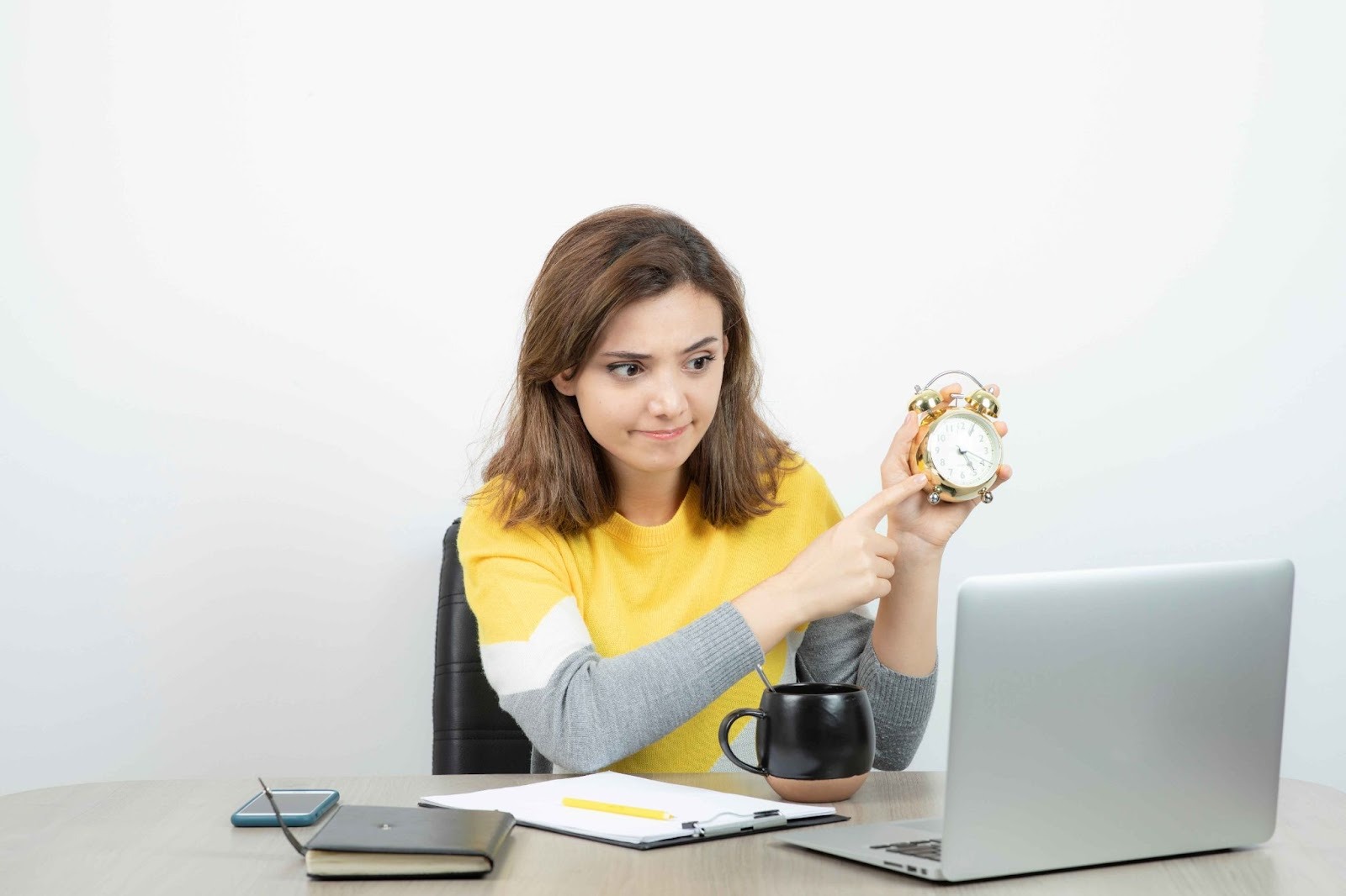 Woman pointing at an alarm clock