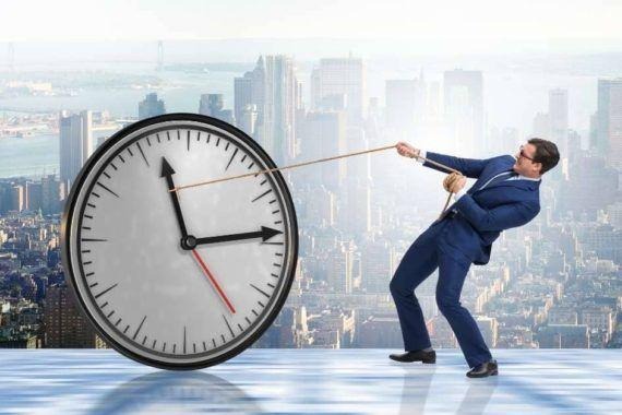 Businessman pulling a giant clock to manage time
