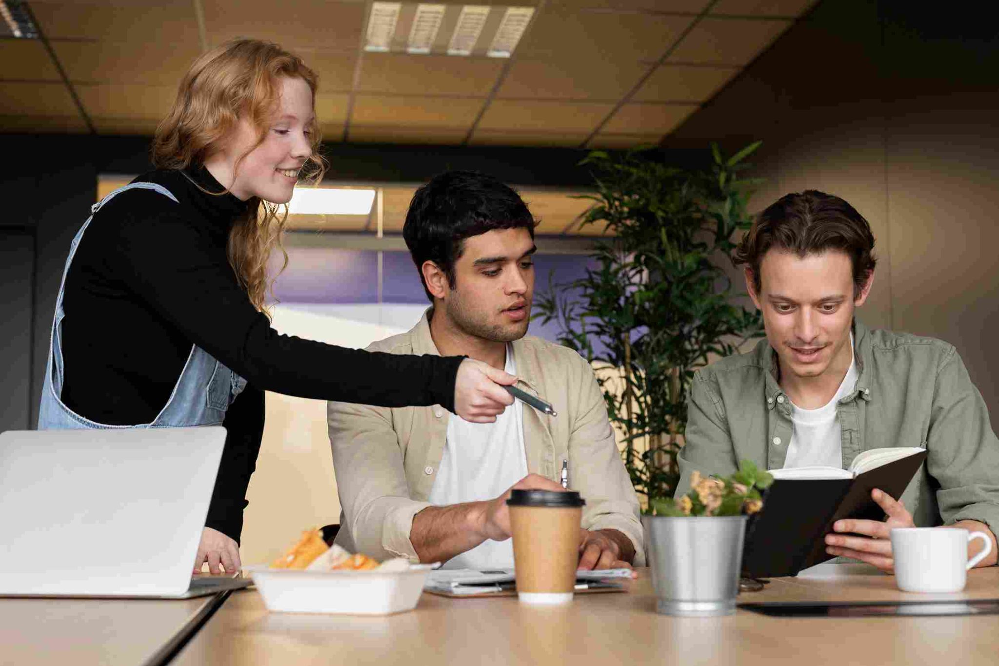 Three people discussing around a table