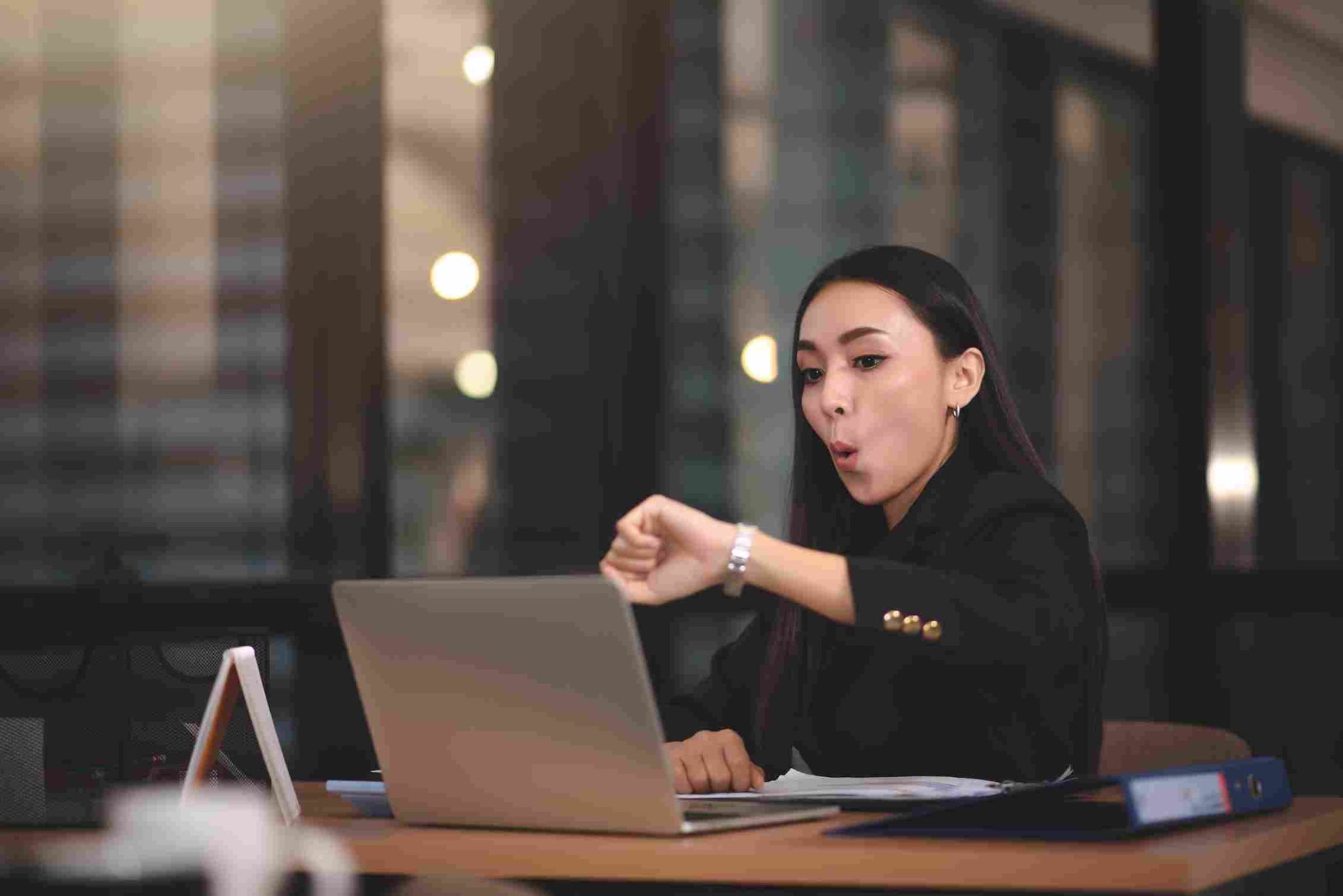 Business woman looking surprised at her laptop
