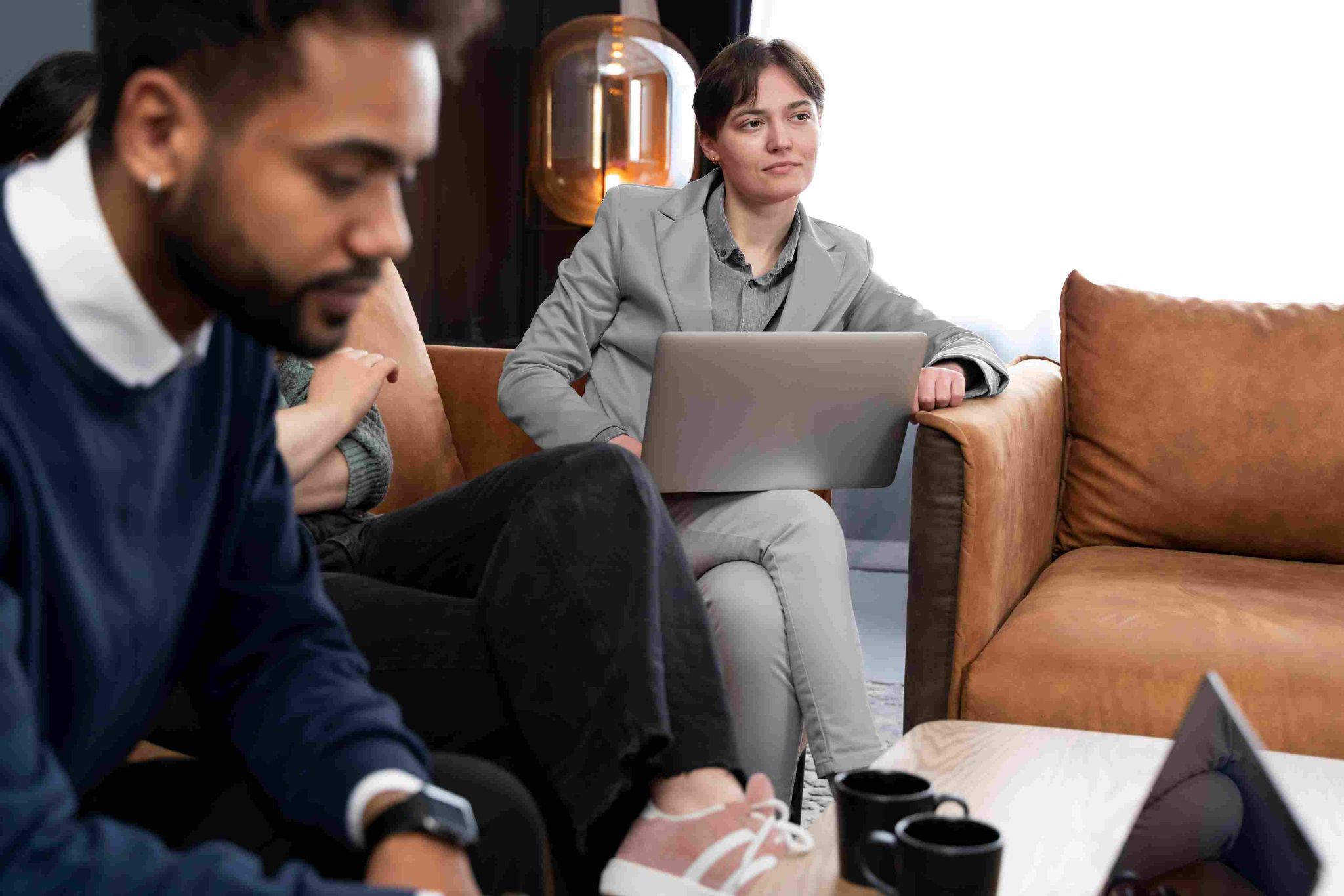 People sitting on a sofa working on laptops