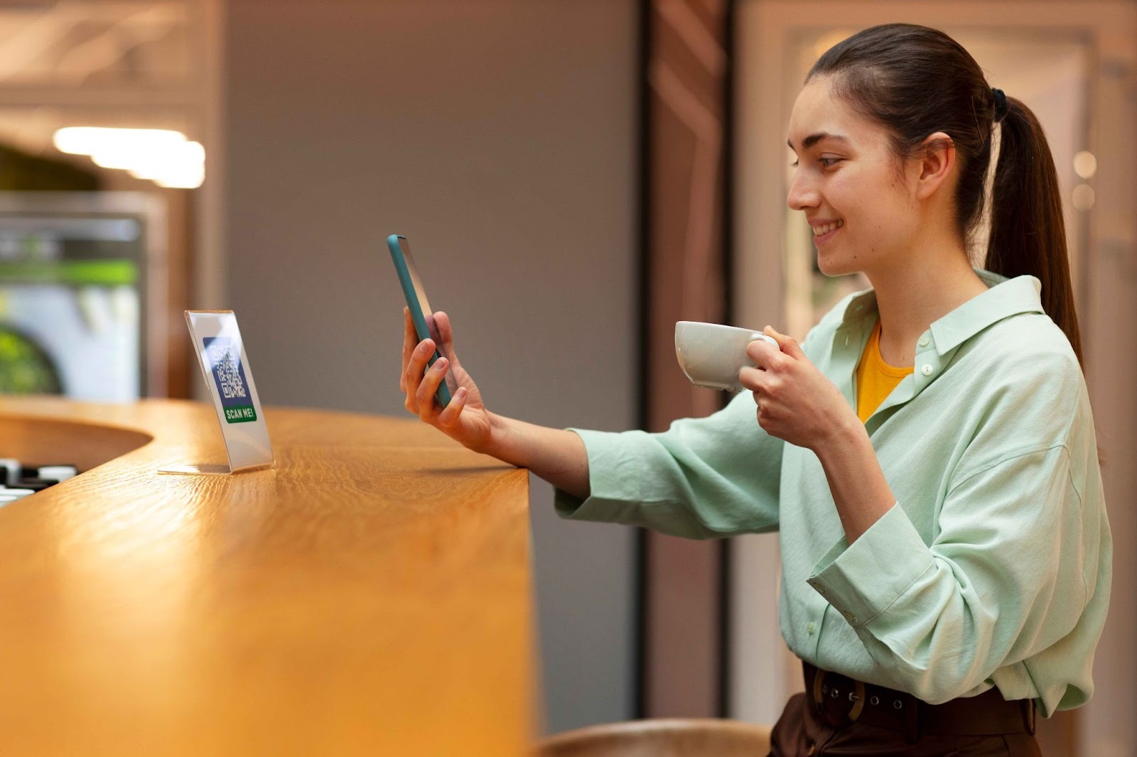 Employee clocking in via mobile app at a cafe